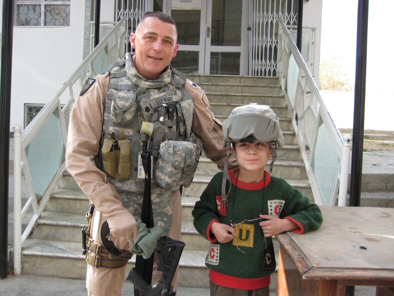 Lt. Col. John Stewart, 519th Combat Sustainment Squadron vice director, takes a photo with Malik during one of the weekly humanitarian missions performed by the coalition. The humanitarian missions provide school supplies, blankets, clothing and food to local villages and schools in their respective area of responsibility.  