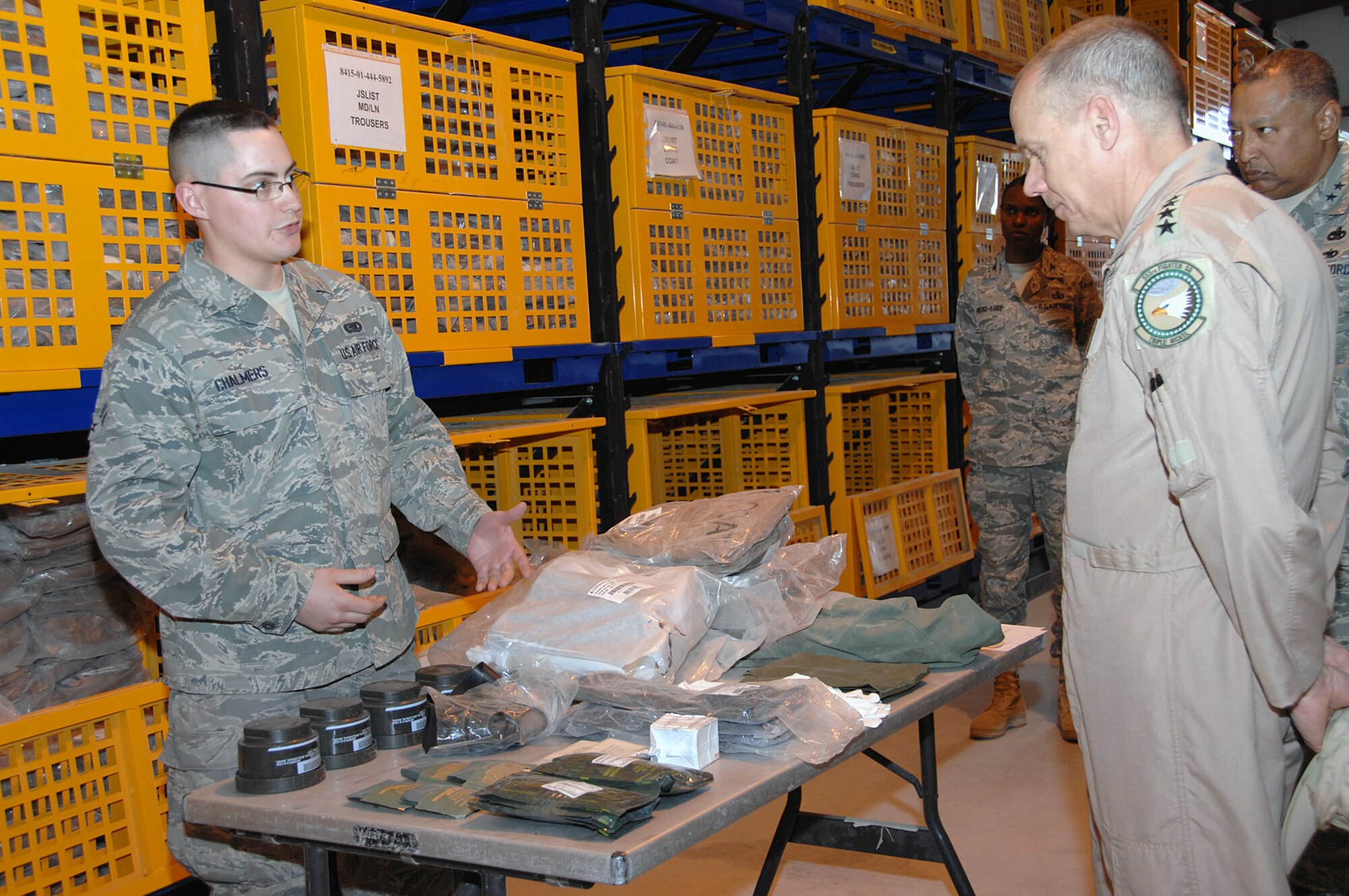 SOUTHWEST ASIA -- Airman 1st Class Randy Chalmers, 386th Expeditionary Logistics Readiness Squadron, briefs Gen. Donald Hoffman, Air Force Materiel Command commander, on the contents of the chemical warfare bag being issued to the general for his trip into the AOR Feb. 9. General Hoffman visited the 386th Air Expeditionary Wing's Expeditionary Theater Distribution Center as part of a multi-base visit to the AOR. (U.S. Air Force photo by Senior Airman Courtney Richardson)