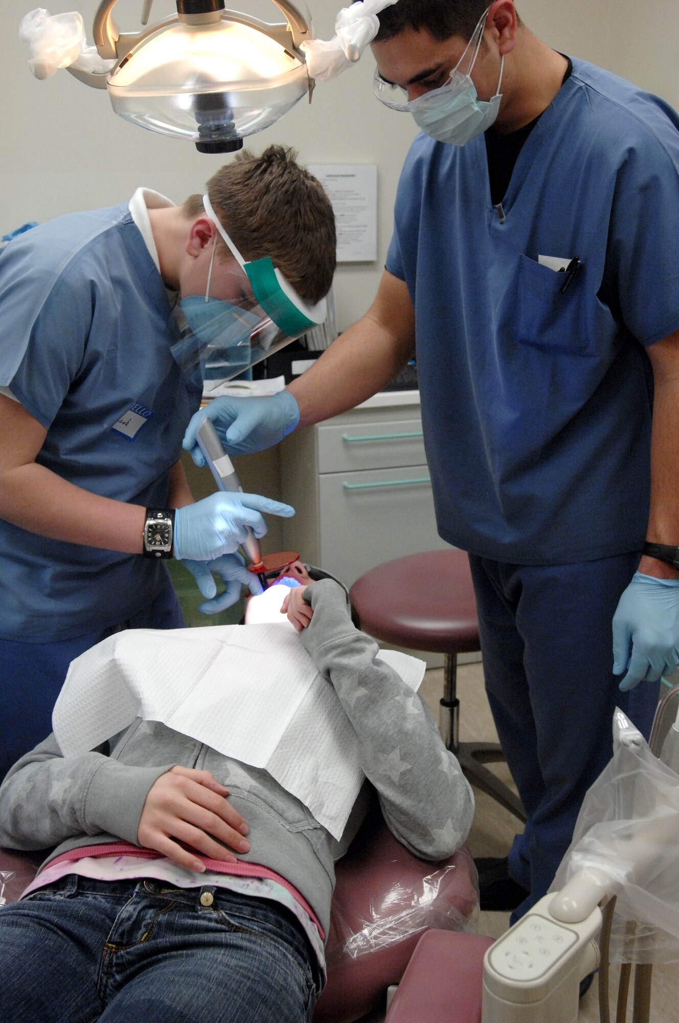 Dental technician Senior Airman Daniel Bonschimpf oversees Aviano High School student Jacob Dohmann as he dries glue on the brackets of a patient's braces Feb. 5. About 200 Aviano High School, Middle School and Elementary School students shadowed various Airmen and civilians throughout the base Feb. 5 as part of Job Shadow Day 2009. (U.S. Air Force photo/Airman 1st Class Ashley Wood)  

