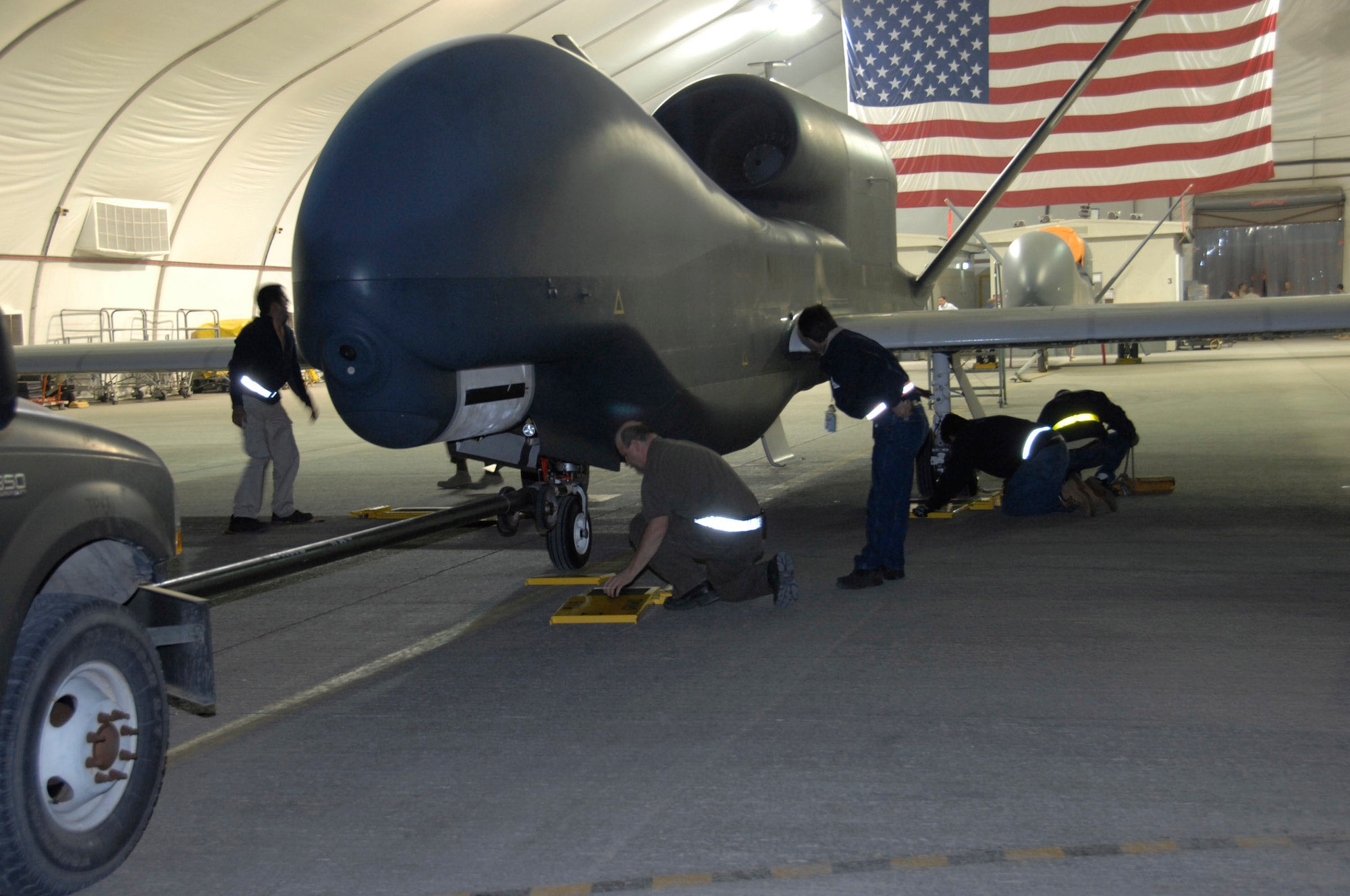 SOUTHWEST ASIA -- Personnel from the Broad Area Maritime Surveillance maintenance detachment here prepare to weigh the Navy Global Hawk to determine how much fuel it consumed on its flight from Naval Air Station Patuxent River, Md. This is the first operational deployment for the BAMS program after its test and development phase. (U.S. Air Force photo by Staff Sgt. Mike Andriacco) (released)