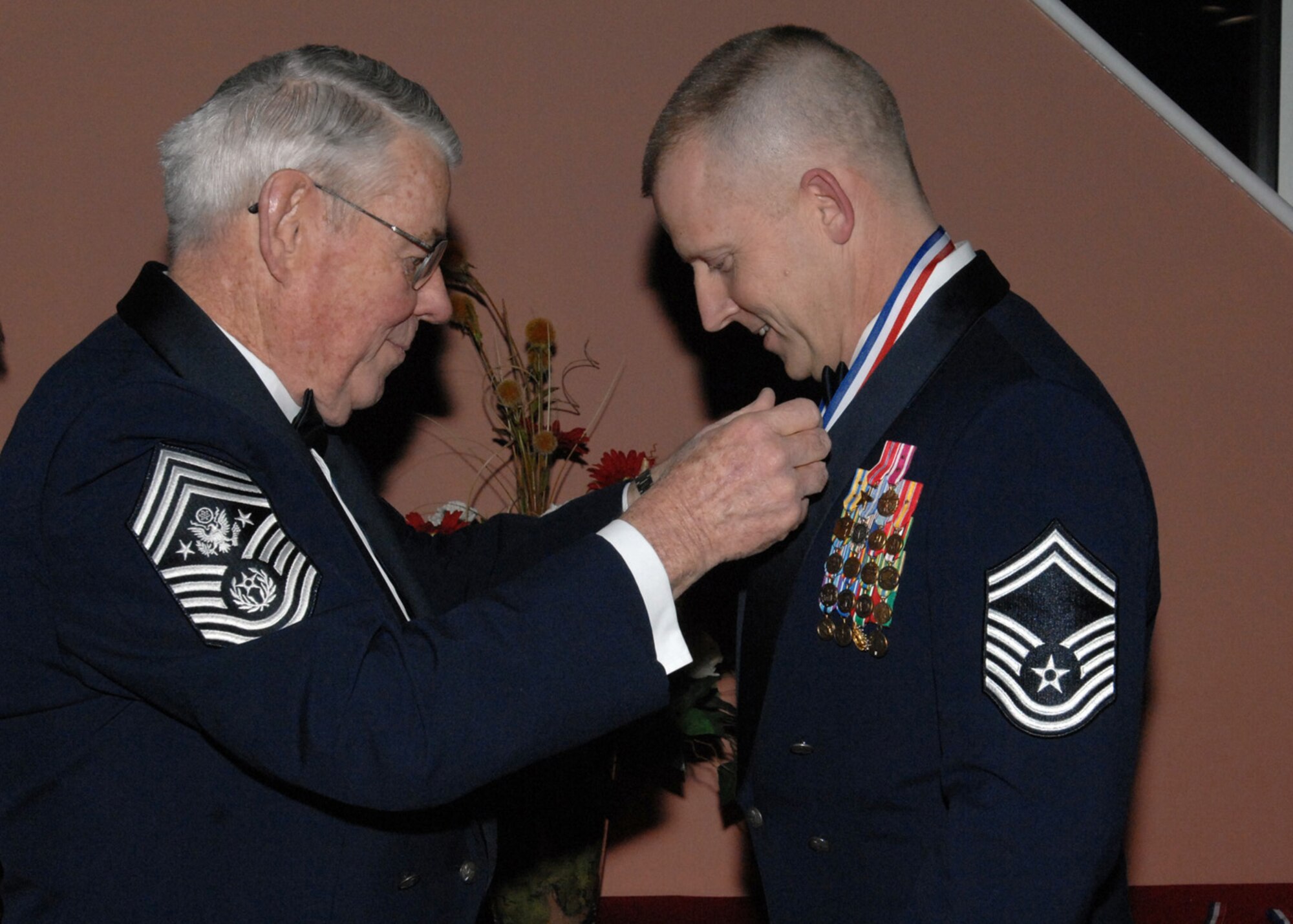 Retired Chief Master Sgt. of the Air Force Robert D. Gaylor places a medallion around the neck of chief select Brad Bowlin, 352nd Maintenance Squadron Accessories Flight Chief, RAF Mildenhall before the Chief’s Recognition ceremony Feb. 7, 2009. The Chief’s Recognition ceremony was had at RAF Mildenhall in a joint effort with RAF Lakenheath and RAF Croughton to welcome the newest Chiefs throughout England into the highest enlisted rank. (U.S. Air Force photo by Senior Airman Teresa M. Hawkins)