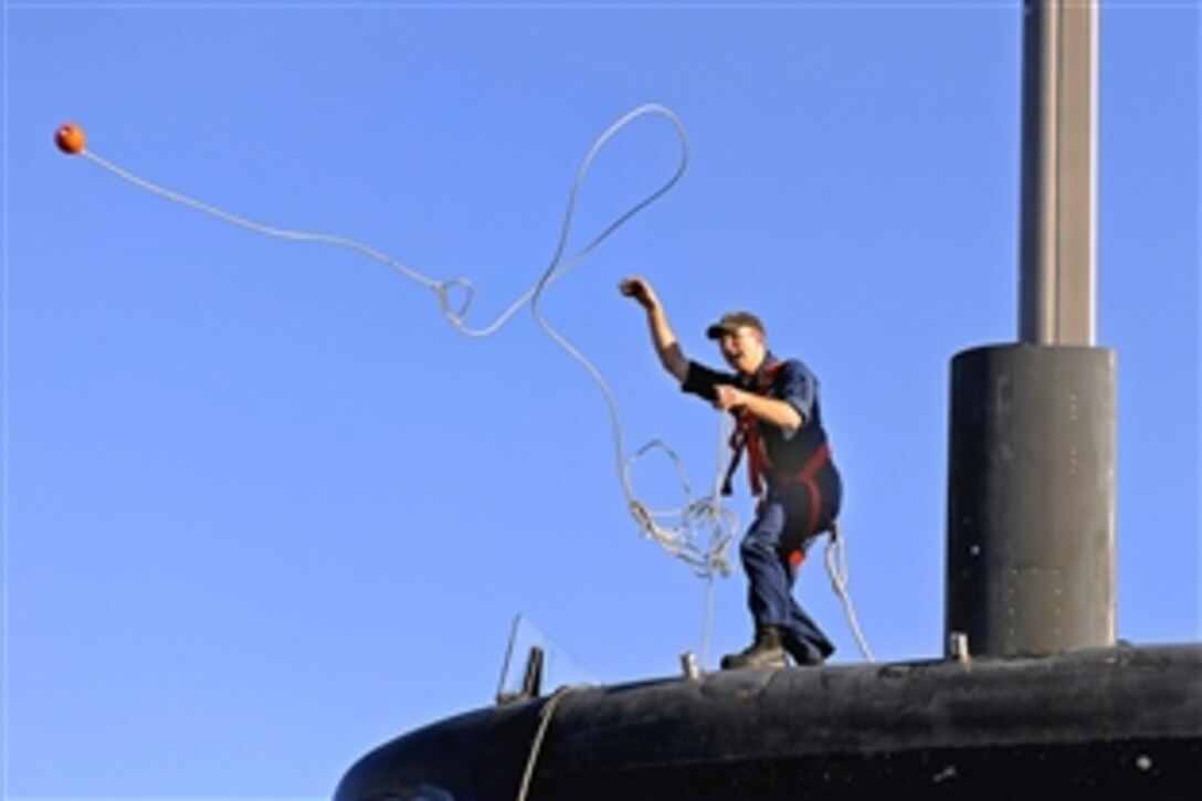U.S. Navy Petty Officer 3rd Class Chuck Youngberg throws a line from the fast-attack submarine USS Pittsburgh to the pier in Groton, Conn., Feb. 4, 2009. Pittsburgh returned to Submarine Base New London from a scheduled six-month deployment to the U.S. Southern Command and Africa Command areas of responsibility.
