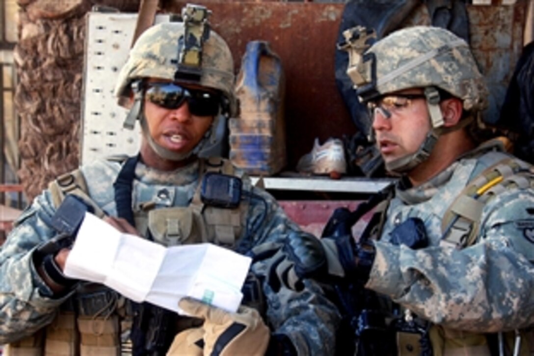 U.S. Army Sgt. 1st Class James Burciaga, right, and Staff Sgt. Rodriguez Cruell review an area map during a combined air-assault mission with Iraqi national police officers in Hussaniyah Nahia, Iraq, Feb. 3, 2009. Burciaga and Cruell are assigned to  Company A, 1st Battalion, 27th Infantry Regiment, currently attached to the 82nd Airborne Division's 3rd Brigade Combat Team.