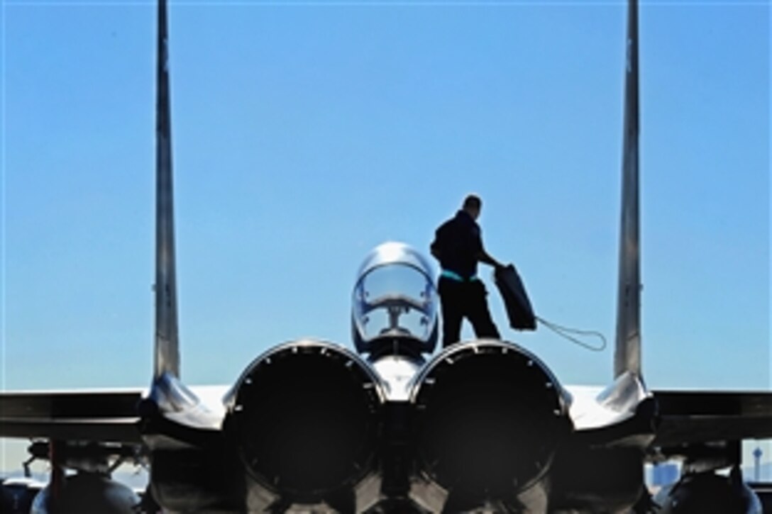 U.S. Air Force Airman 1st Class Joey Cherry, an F-15E Strike Eagle crew chief, prepares to put intake covers on his jet after a training mission during Exercise Red Flag on Nellis Air Force Base, Nev., Jan. 30, 2009. Red Flag is a multinational exercise providing a realistic environment to practice combat scenarios.