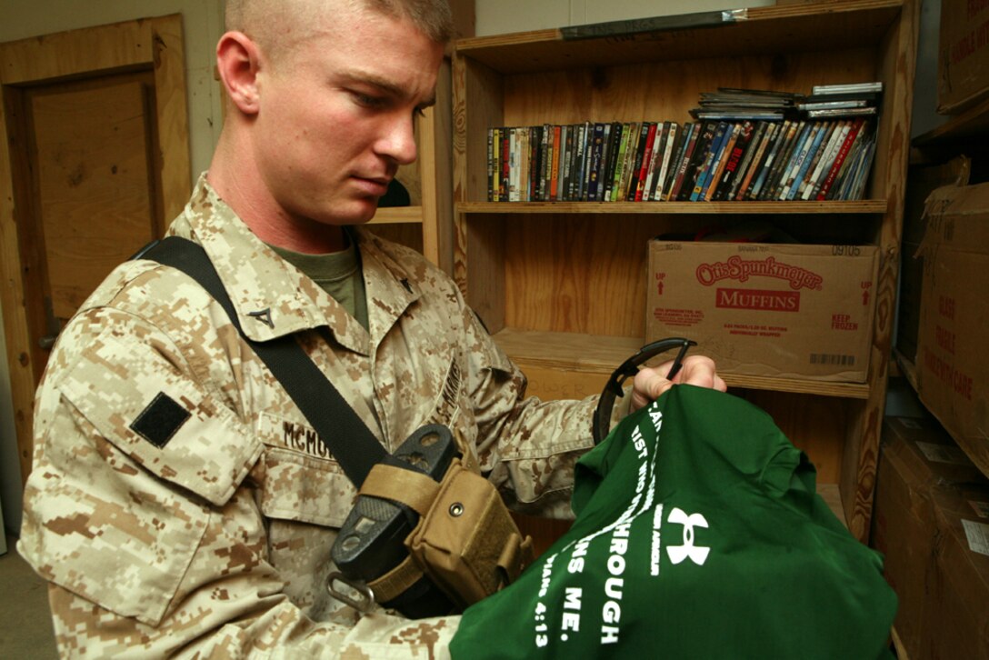 Lance Cpl. Marcus McMurray, a command-operations-center journal clerk with Headquarters Company, Regimental Combat Team 8, decides to take a donated shirt from the chapel annex here. Marines and sailors enjoy the ability to leisurely stroll through the well organized store, sifting through free hygiene items and other donated goods.