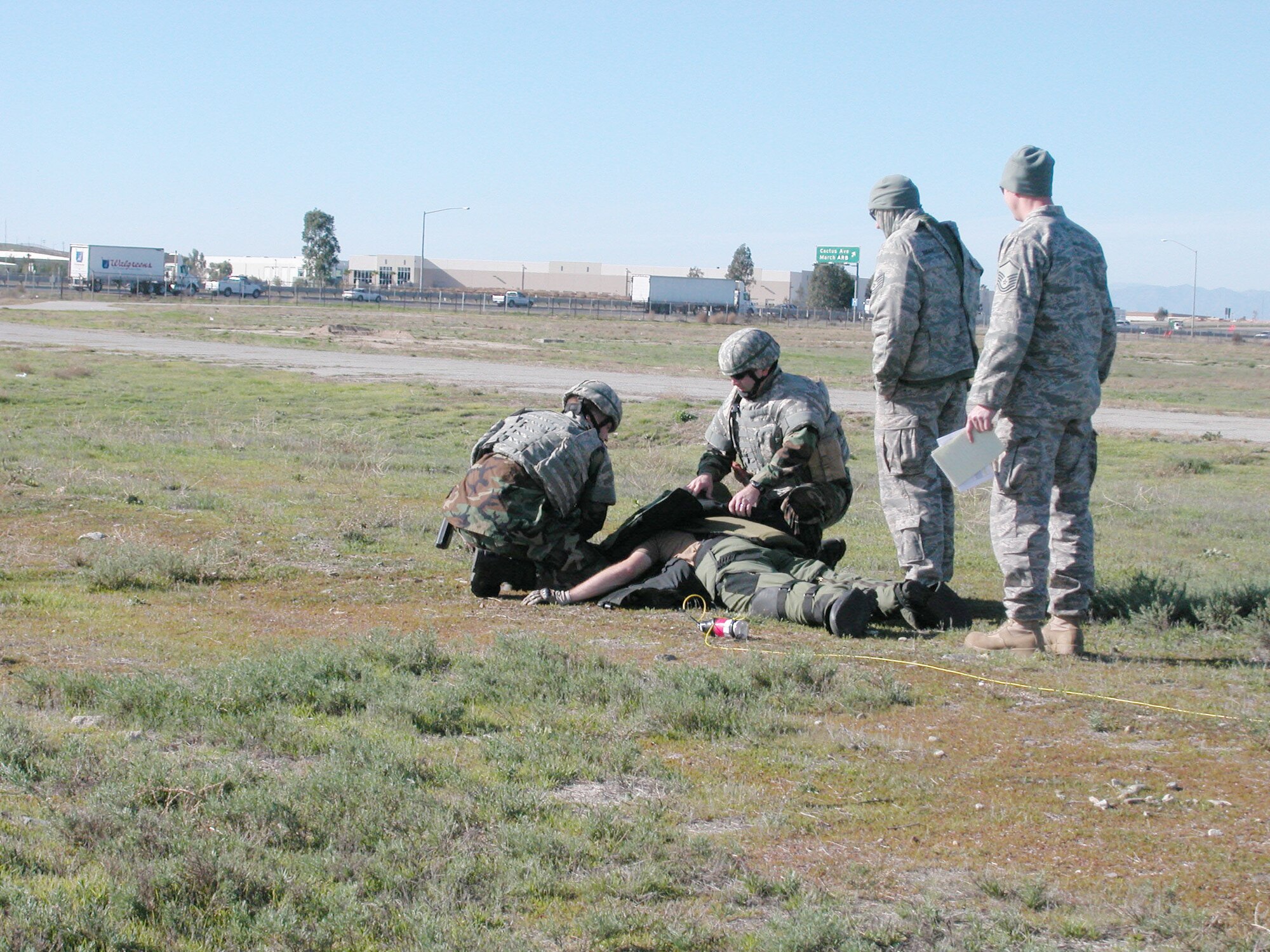 Tech. Sgt. Chris Cheshire and Staff Sgt. Justin Grounds (left) help Tech. Sgt. Chris Campbell, who simulates being wounded by a sniper. Evaluaters Tech. Sgt. Brooks Rhoads and Master Sgt. Justin Alonzo (right) observe how they handle the situation.  (U.S Air Force photo by Staff Sgt. Megan Crusher)