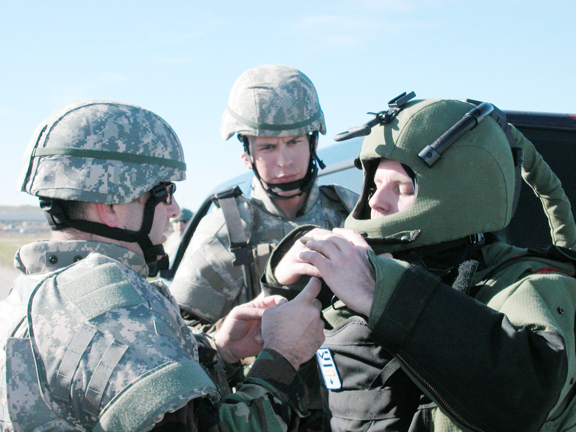 Tech. Sgt. Chris Cheshire (left) helps Tech. Sgt. Chris Campbell put on on the EOD-8 bomb suit during 452 CES/EOD’s IED training at March ARB. Staff Sgt. Justin Grounds
(center) observes. (U.S Air Force photo by Staff Sgt. Megan Crusher)