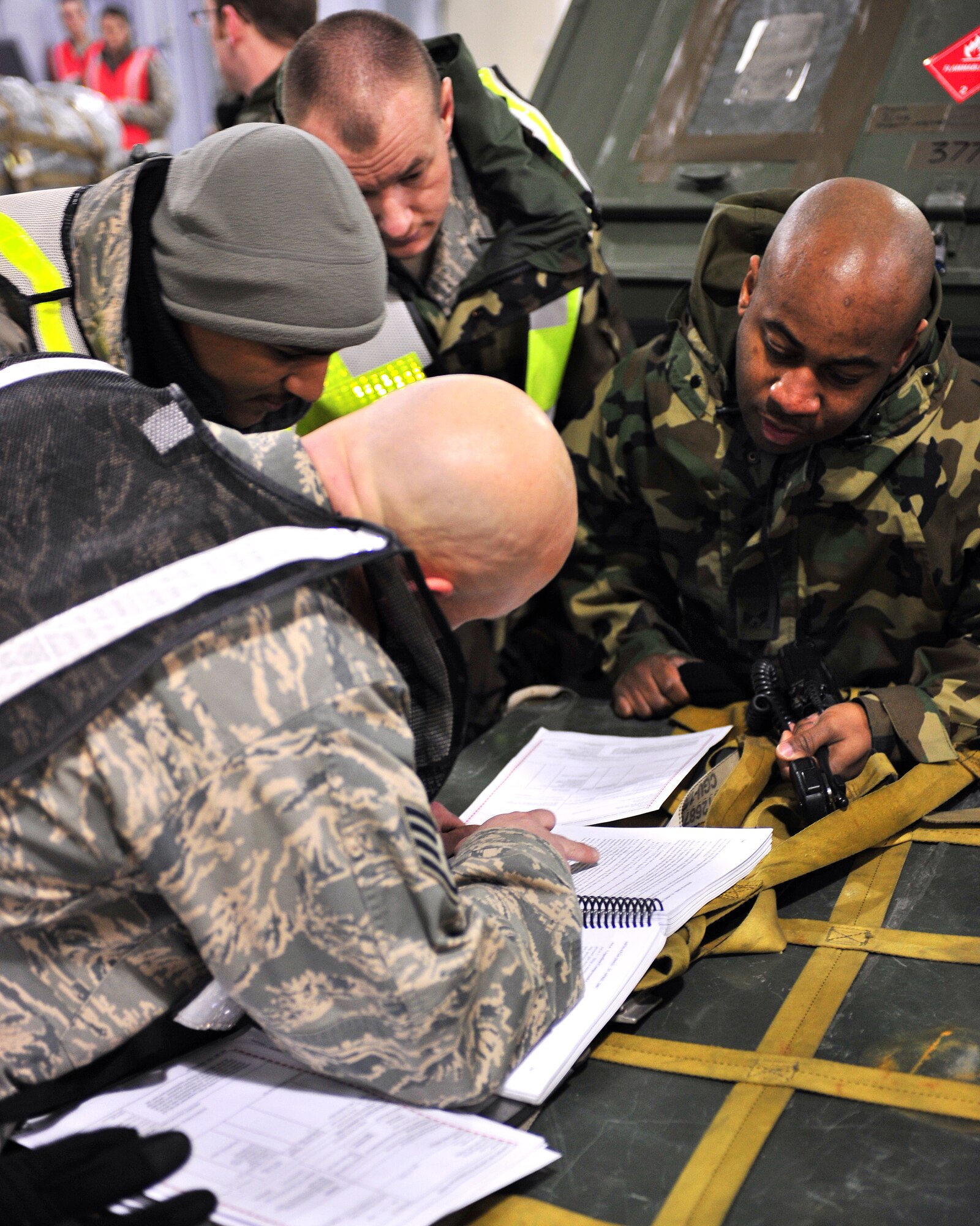 Airmen from the 354th Logistics Readiness Squadron reference a material safety data sheet during an operational readiness exercise, Feb. 9, 2009. It is important that the respective MSDS is referenced before any chemical is stored, handled, or utilized. (U.S Air Force photo/Airman 1st Class Willard E. Grande II)