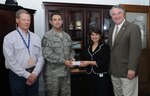 Retired colonel Buster Horlen (left), now a San Antonio Rodeo ticket committee volunteer and Burns Ranch general manager; Sonya McDonald, Randolph-Brooks Federal Credit Union sales operations vice president; and Thad Ziegler (right), Thad Ziegler Glass, Ltd. president; present 275 San Antonio Rodeo tickets to Chief Master Sgt. Max Grindstaff, 12th Flying Training Wing command chief master sergeant, on Feb. 9. For the last five years, businesses like Randolph-Brooks and Thad Ziegler have donated money to purchase tickets for junior enlisted Airmen to attend the rodeo. In addition to providing free tickets to Airmen, the San Antonio Rodeo committee donates to the Army at Ft. Sam Houston and wounded warriors currently under care at Brooke Army Medical Center. Military members who aren't able to receive a ticket can still attend the rodeo any Friday, show their military ID and receive free admission. (U.S. Air Force photo by Rich McFadden)