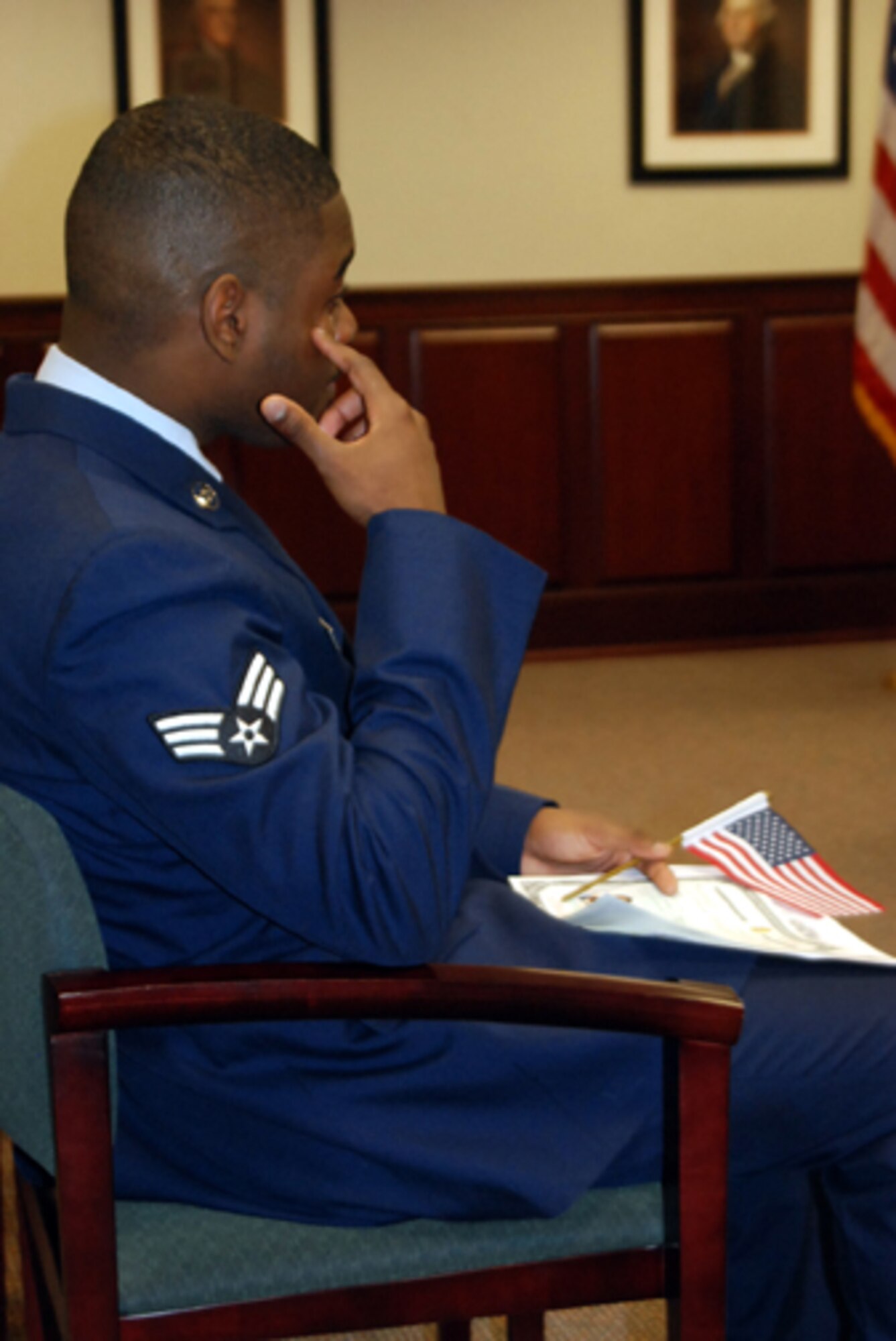 Senior Airman Darren Webster, 305th Maintenance Operations Squadron, watches an emotional video about what it means to be a U.S. citizen after his Oath of Citizenship ceremony Feb. 9 in Mount Laurel, N.J. Airman Webster worked for 10 years to earn his U.S. citizenship. (U.S. Air Force photo/Senior Airman Bekah Phy)