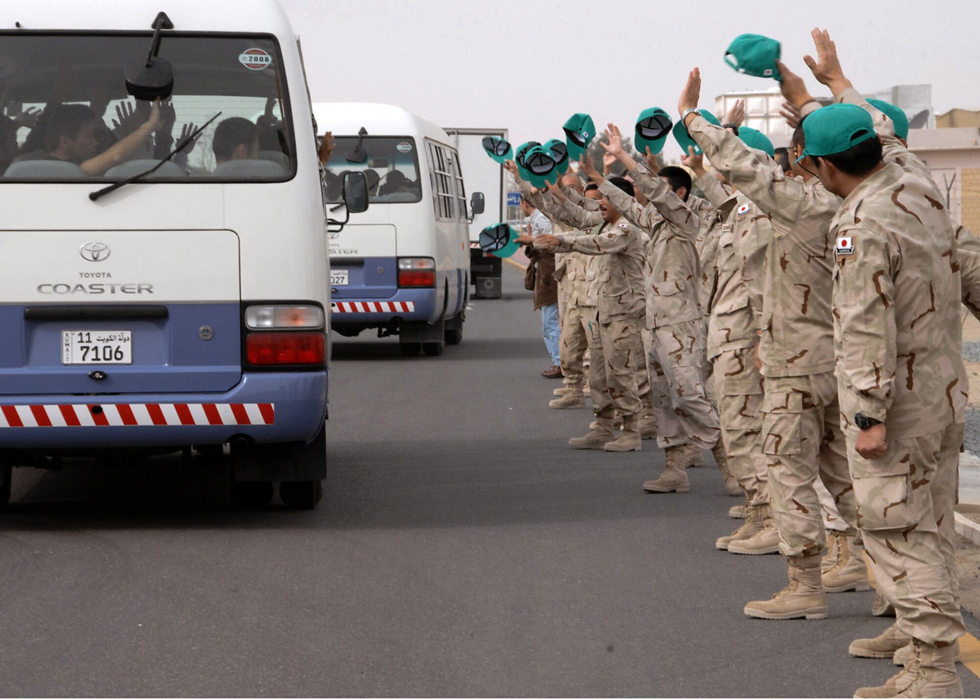 Airmen from the Japanese Air Self Defense Force redeployment group wave goodbye as their comrades are bused to the local airport for their flights back to Japan at an air base in Southwest Asia Feb. 10. For almost five years, more than 3,600 Japanese airmen have been part of the JASDF contingent. (U.S. Air Force photo/Senior Airman Courtney Richardson)