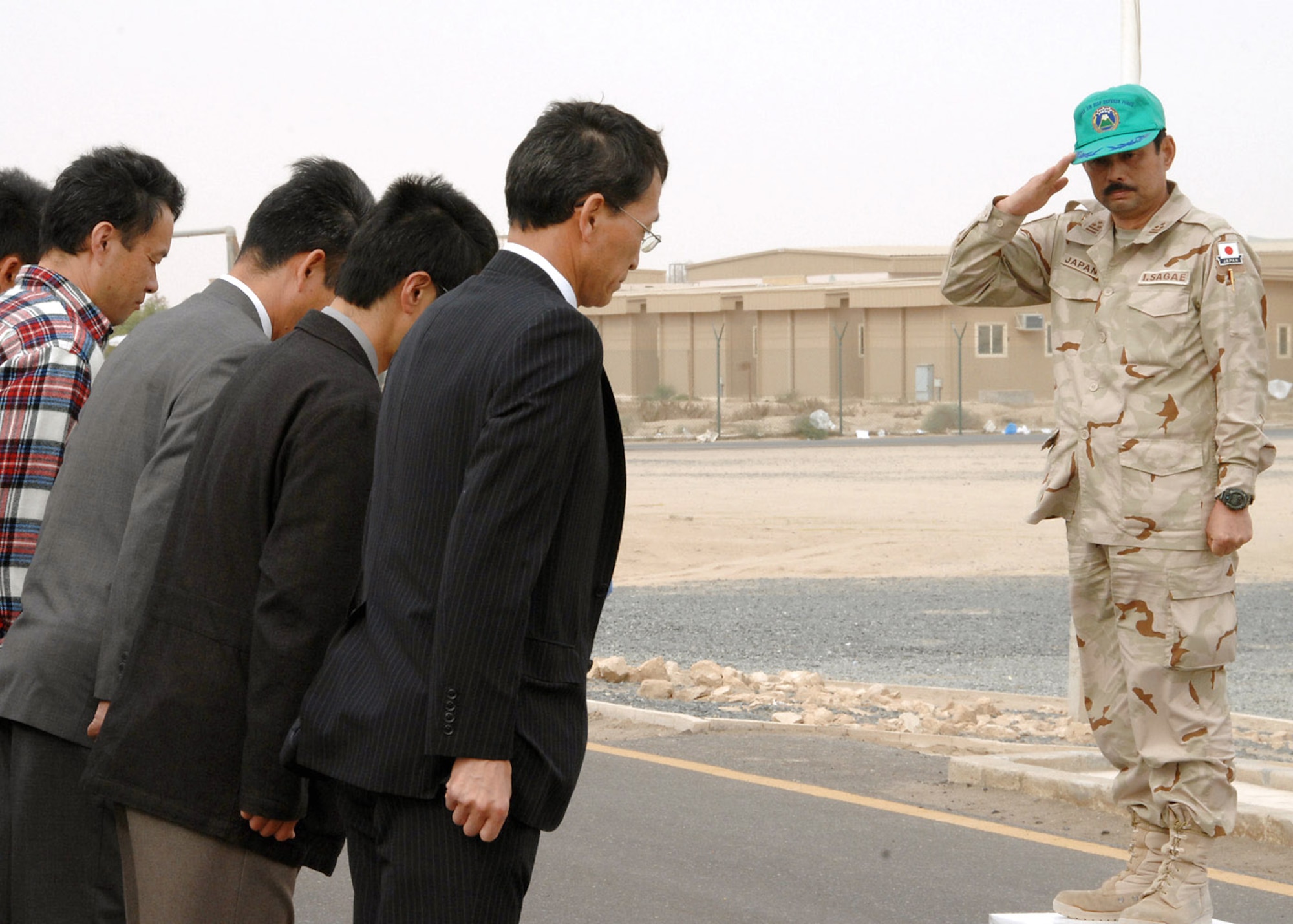 Japanese Air Self Defense Force Col. Isami Sagae renders a salute to the members of JASDF before they depart for Japan at an air base in Southwest Asia Feb. 10. After the JASDF mission was complete, more than 100 members remained behind to restore the facilities they used and to ship equipment back to Japan. (U.S. Air Force photo/Senior Airman Courtney Richardson)