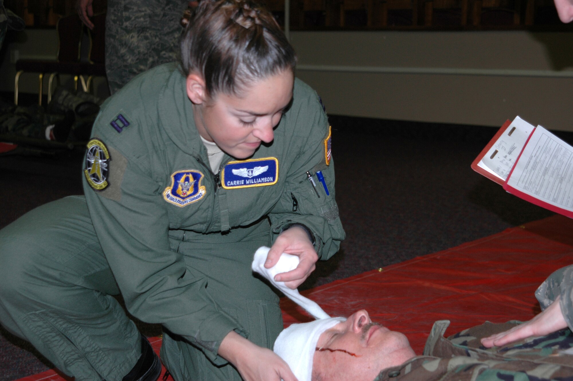 Capt. Carrie Williamson, an Air Force Reservist with the 34th Aeromedical Evacuation Squadron, dresses a head wound on a mock patient during a mass-casualty training exercise Feb. 7, 2009, at Peterson Air Force Base, Colo. The annual training is designed to improve coordination and communication between medical personnel aimed at improving the quality and timeliness of care provided to the injured. Captain Williamson joined more than 40 other medical personnel in tending to approximately 25 mock patients with varying degrees of injuries. (U.S. Air Force photo/Tech. Sgt. Daniel Butterfield)