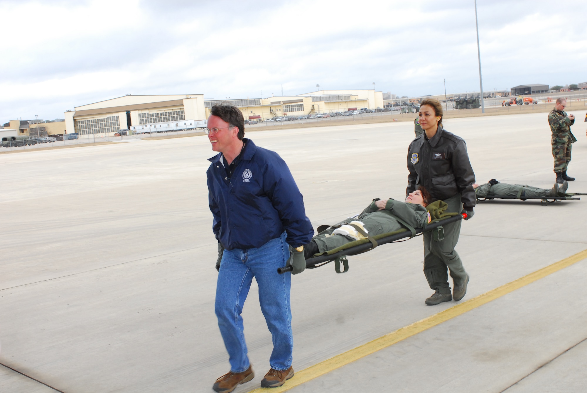 Dr. David Lakey, commissioner of the Department of State Health Services (DSHS), helps an Airman carry a litter “patient” into the back of a C-17 aircraft during a training exercise. He and three other key staff members from the DSHS visited Lackland Air Force Base, Texas, Feb. 7 to learn about the aircraft and its medical evacuation capabilities. (TXMF photo by Tech. Sgt. Rene 