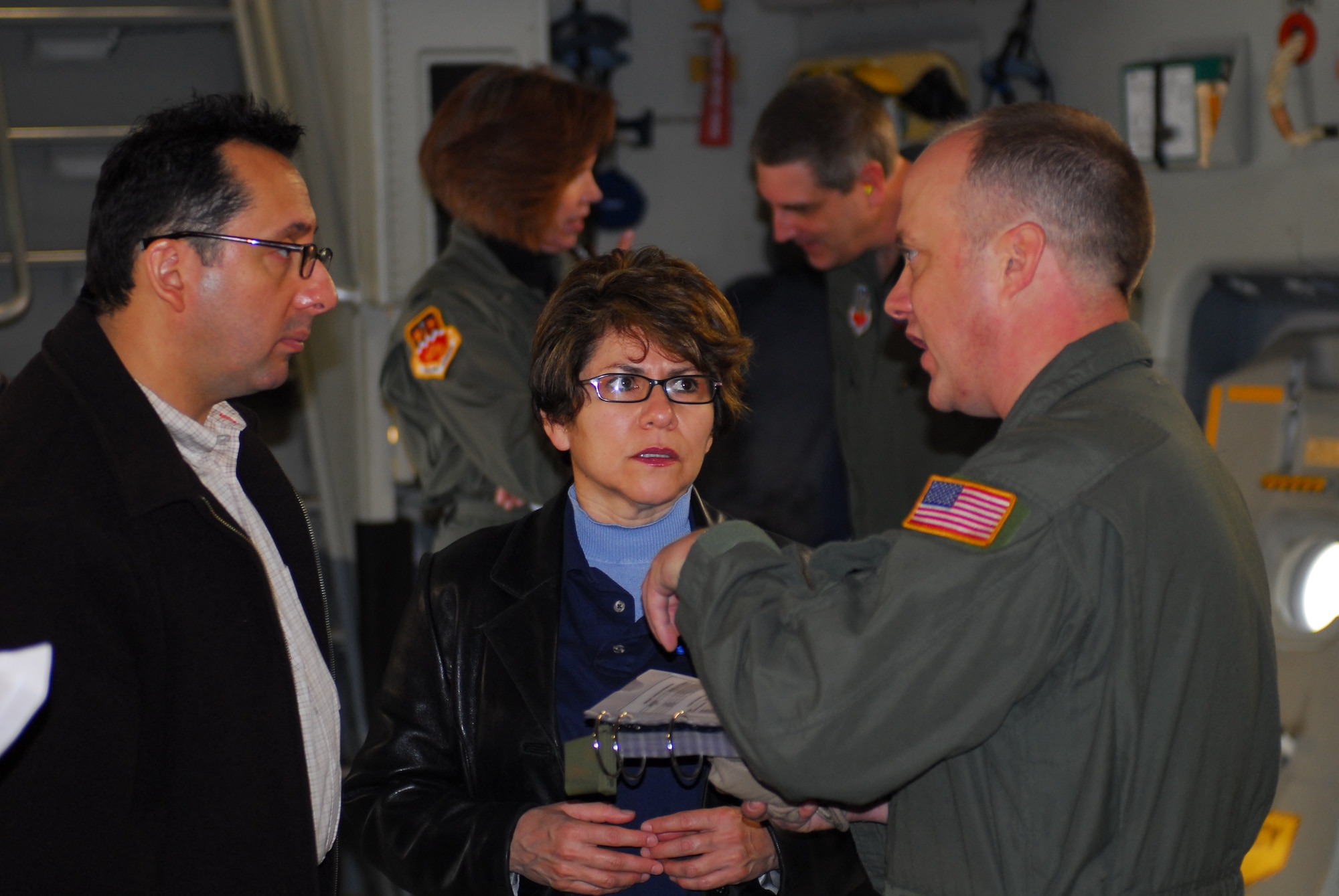 Dr. Adolfo Miguel Valadez, Department of State Health Services (DSHS) assistant commissioner for Prevention and Preparedness Services, and Evelyn Delgado, DSHS assistant commissioner for Family Community Health Services, listen to Chief Master Sgt. Rodney Christa, 433rd Aerospace Evacuation Squadron superintendent, brief them about the C-17 aircraft prior to takeoff. Colonel McNabb and the DSHS guests boarded the C-17 at Lackland Air Force Base Feb. 7 to learn about the aircraft and its medical evacuation capabilities. (TXMF photo by Tech. Sgt. Rene Castillo)