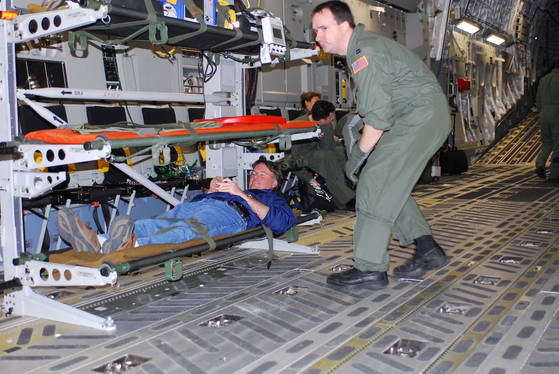Capt. Bill Reed checks on Dr. David Lakey, commissioner of the Department of State Health Services, who takes the role of a litter patient during an exercise aboard a C-17 aircraft Feb. 7. He and three other key staff members from the DSHS board the C-17 at Lackland Air Force Base, Texas, to learn about the aircraft and its medical evacuation capabilities. (TXMF photo by Tech. Sgt. Rene Castillo)