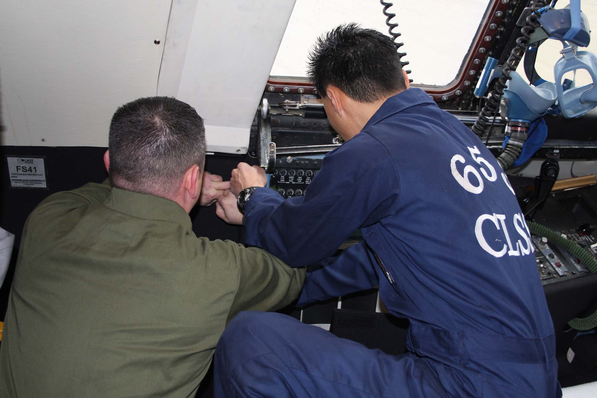 Tech. Sgt. Mark McQueen, left, and Tech. Sgt. Don Kim, both from the 653rd Combat Logistics Support Squadron, Robins Air Force Base, Ga., install armor on the flight deck of a C-5 Galaxy belonging to the 445th Airlift Wing.  The two airmen are part of a four-man team from Robins Air Force Base responsible for the installation of armor on all the wing’s C-5 aircraft.  The team arrived Jan. 26 and anticipates completing the job by the end of the month. (Air Force photo/Stacy Vaughn)