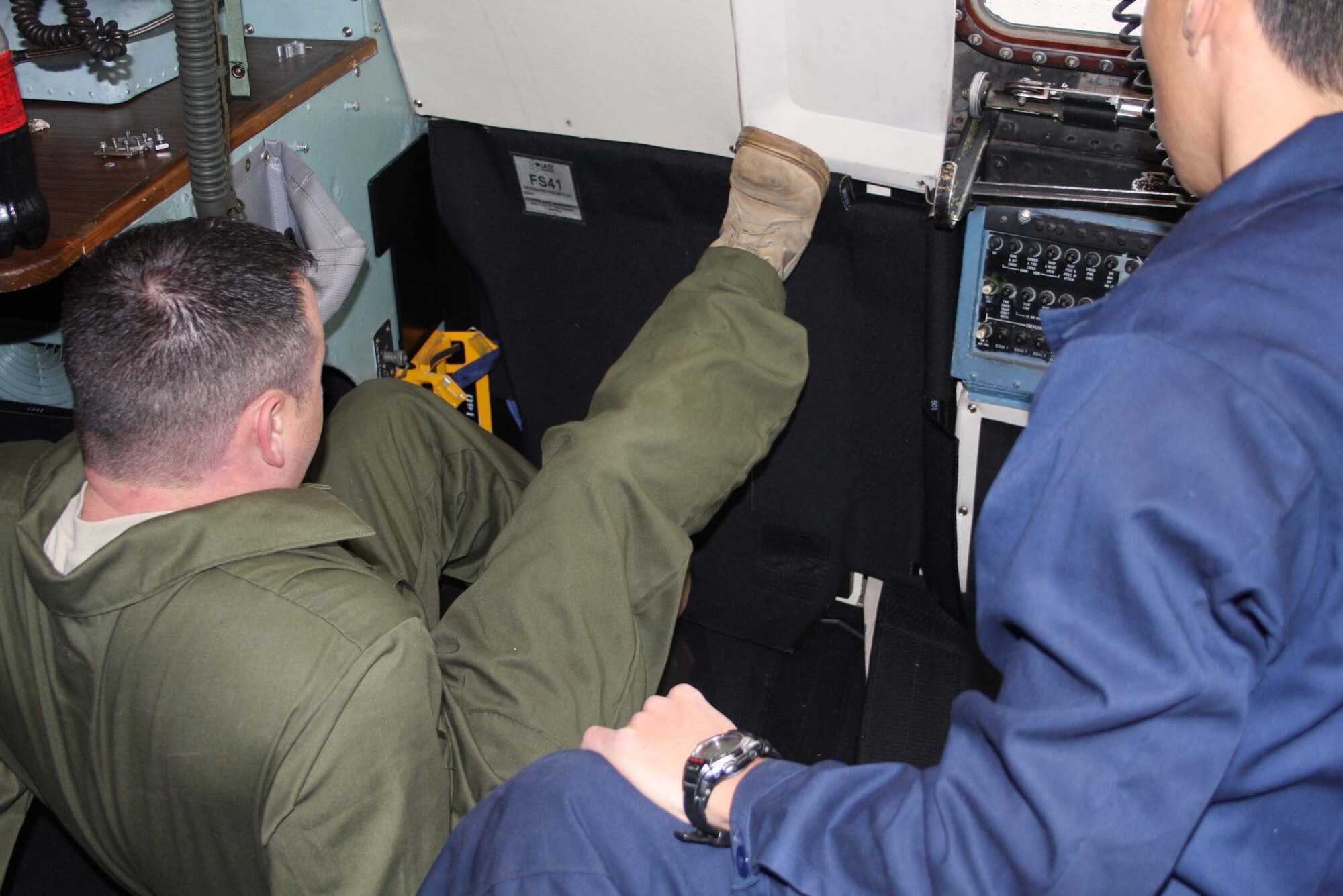 WRIGHT-PATTERSON AFB, Ohio – Tech. Sgt. Mark McQueen, left, 653rd Combat Logistics Support Squadron, Robins Air Force Base, Ga., uses all of his strength to install a piece of armor on a C-5 aircraft as Tech. Sgt. Don Kim, 653rd Combat Logistics Support Squadron, looks on.  The weight of the armor is approximately 2,100 pounds.   Of that, 1,500 pounds is carried into the flight deck, 150 pounds to the left and right of the jump doors and the rest to the liquid oxygen compartment.  (Air Force photo/Stacy Vaughn)