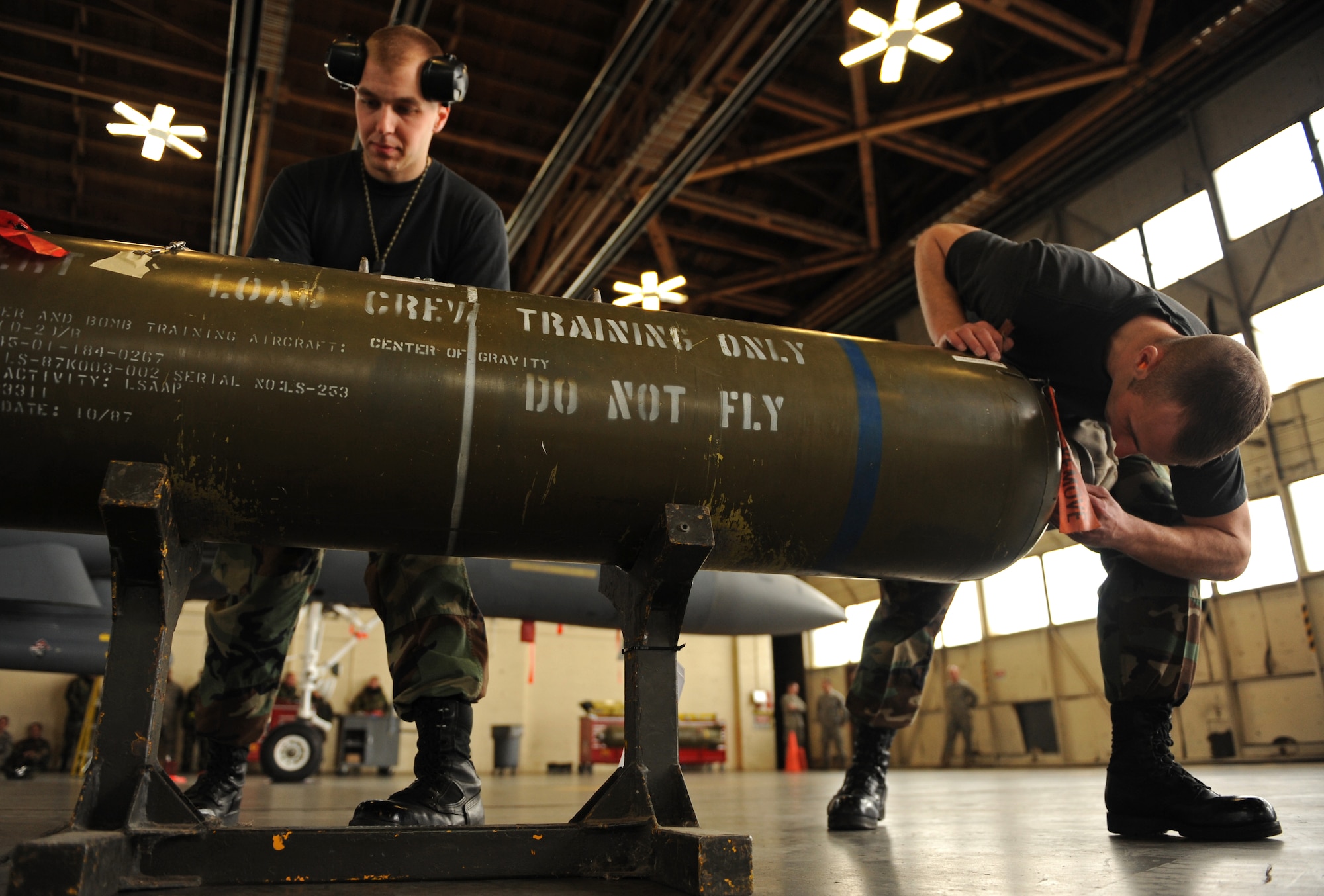 MOUNTAIN HOME AIR FORCE BASE, Idaho -- Senior Airman Troy Brigance (right), 389th Aircraft Maintenance Unit, checks a training bomb for any defects while Staff Sgt. Joseph Hall, 389th AMU, prepares the bomb to be moved during the bomb-loading competition Feb. 5. The competition consists of loading six munitions onto the aircraft as quick as possible and without any errors to include safety issue and technical issues. The winners will be announced during the 366th Operations Group banquet in April. (U.S. Air Force photo/ Senior Airman Ryan Crane)