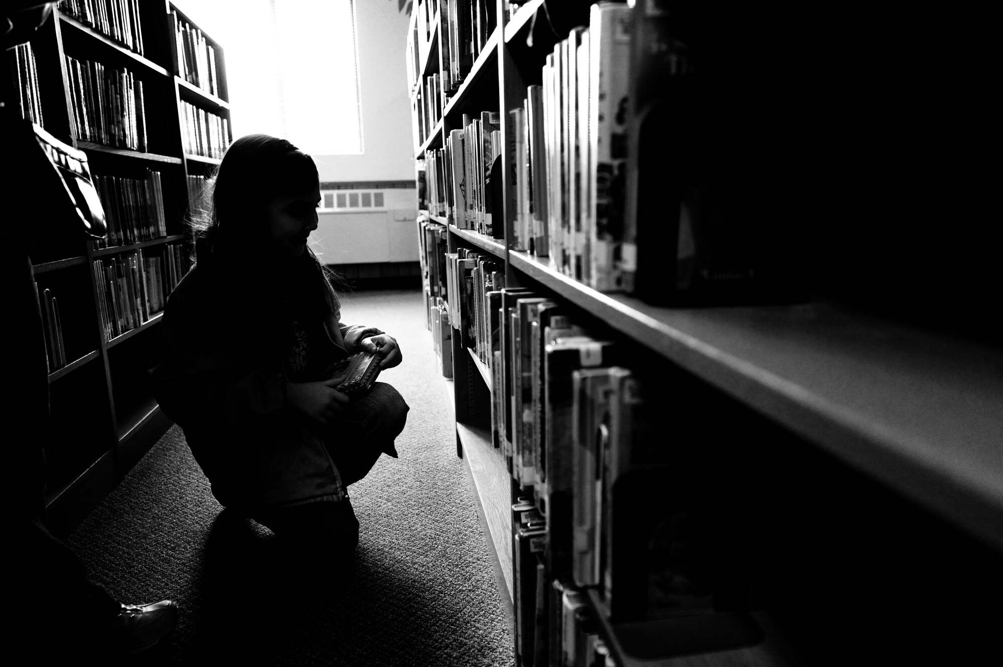 MOUNTAIN HOME AIR FORCE BASE, Idaho -- Jessie Watt searches through the thousands of books in the children’s section of the base library Jan 27. The library offers numerous services to military members and their families in the form of books, movies, internet access and children’s story time. (U.S. Air Force photo/ Senior Airman Ryan Crane)