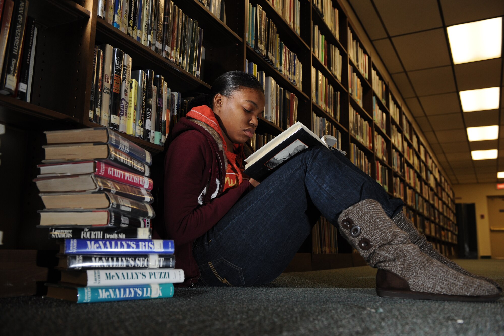MOUNTAIN HOME AIR FORCE BASE, Idaho -- Airman 1st Class DeAira McDonald, 366th Medical Support Squadron, reads a book in the isle of the base library Jan. 28. The base library offers numerous services to military members and their families in the form of movies, books, internet access and children’s story time. (U.S. Air Force photo/ Airman 1st Class Renishia Richardson)