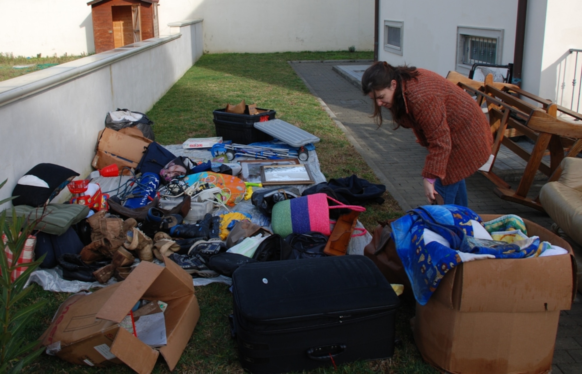 Military spouse Natalie Martinka searches for a pair of dry shoes Feb. 9 amidst items drying from the Feb. 6 flood which struck the Pisa, Livorno and Camp Darby, Italy areas.  (U.S. Army photo by Joyce Costello.)