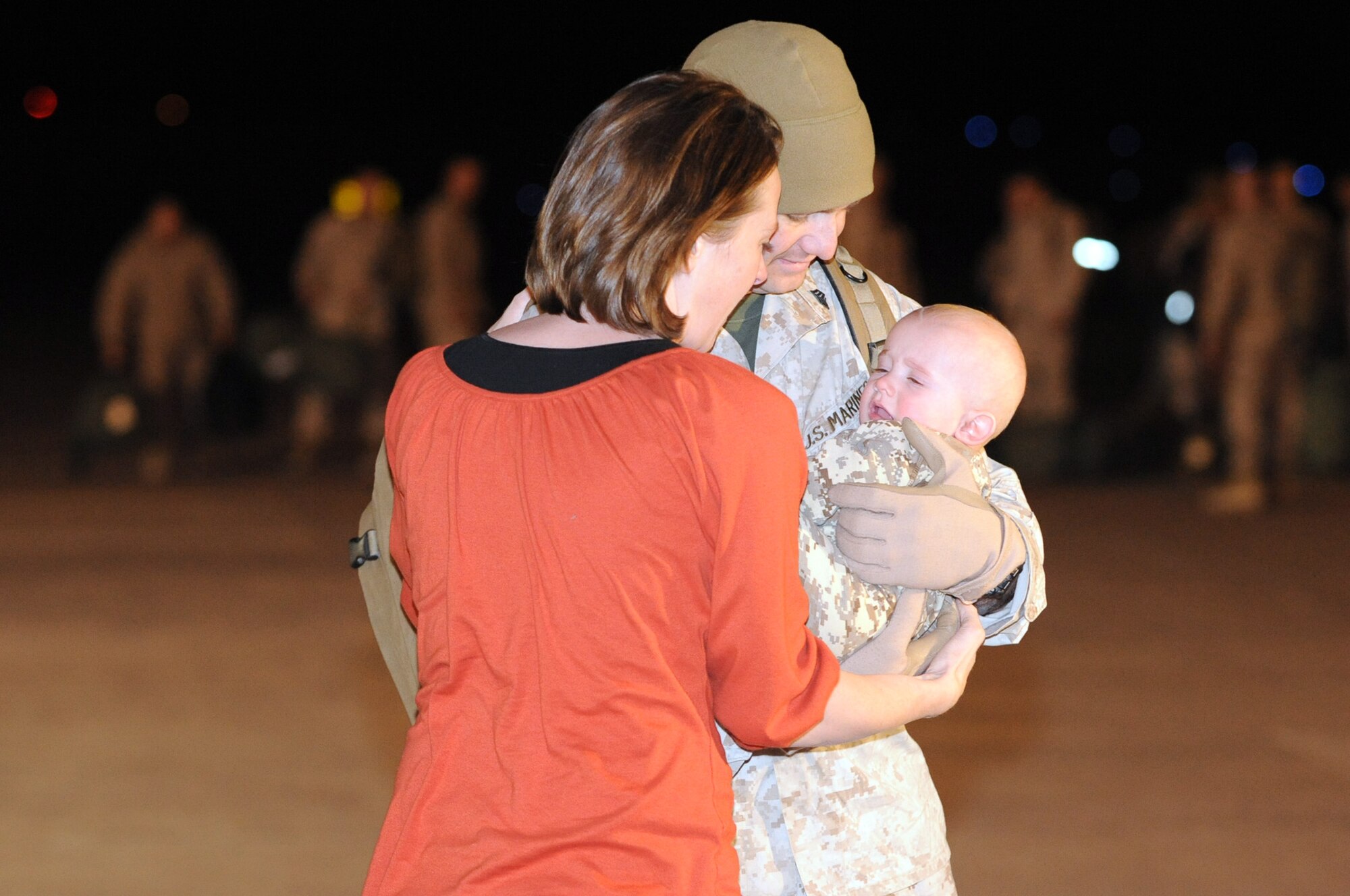 BUCKLEY AIR FORCE BASE, Colo. -- Michelle Figler welcomes home her husband Sgt. Josh Figler. This was his first time holding his son Ryder. The Marines returned to Hangar 909 here, Jan. 31, from a seven month deployment to the Anbar Province, Iraq, where they performed tactical air operations. (U.S. Air Force photo by Senior Airman Christopher Bush)