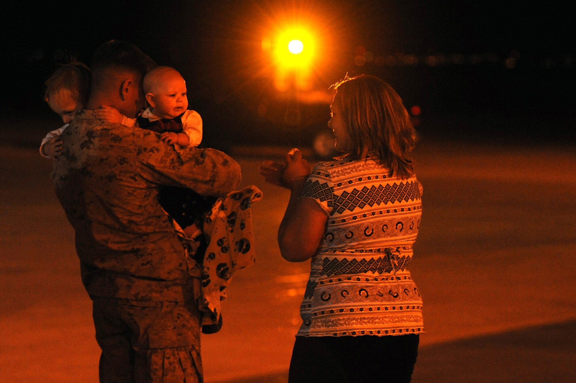 BUCKLEY AIR FORCE BASE, Colo. -- Marine Cpl. Tyler Short returns home to the waiting arms of his children, Mason and Traci, and his wife, Miranda, outside Hangar 909. This was his first time holding his daughter Traci who was born while he was deployed. The Marines returned to Buckley, Jan. 31, from a seven month deployment to the Anbar Province, Iraq, where they performed tactical air operations. (U.S. Air Force photo by Senior Airman Christopher Bush)