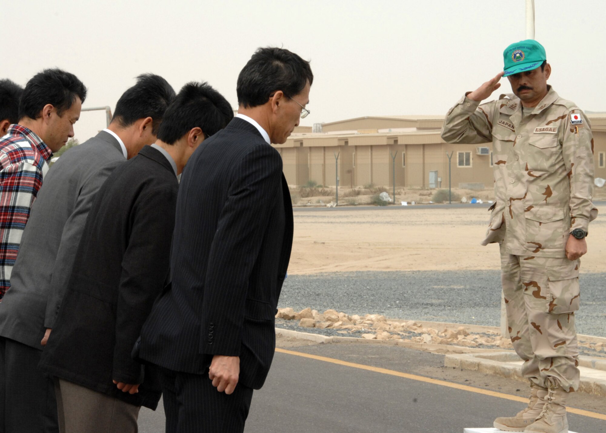 SOUTHWEST ASIA -- Japanese Air Self Defense Force Col. Isami Sagae renders a salute to the members of JASDF before they depart for Japan at an air base in Southwest Asia, Feb. 10. After the JASDF mission was complete, more than 100 members remained behind to restore the facilities they used and to ship equipment back to Japan. (U.S. Air Force photo/Senior Airman Courtney Richardson)