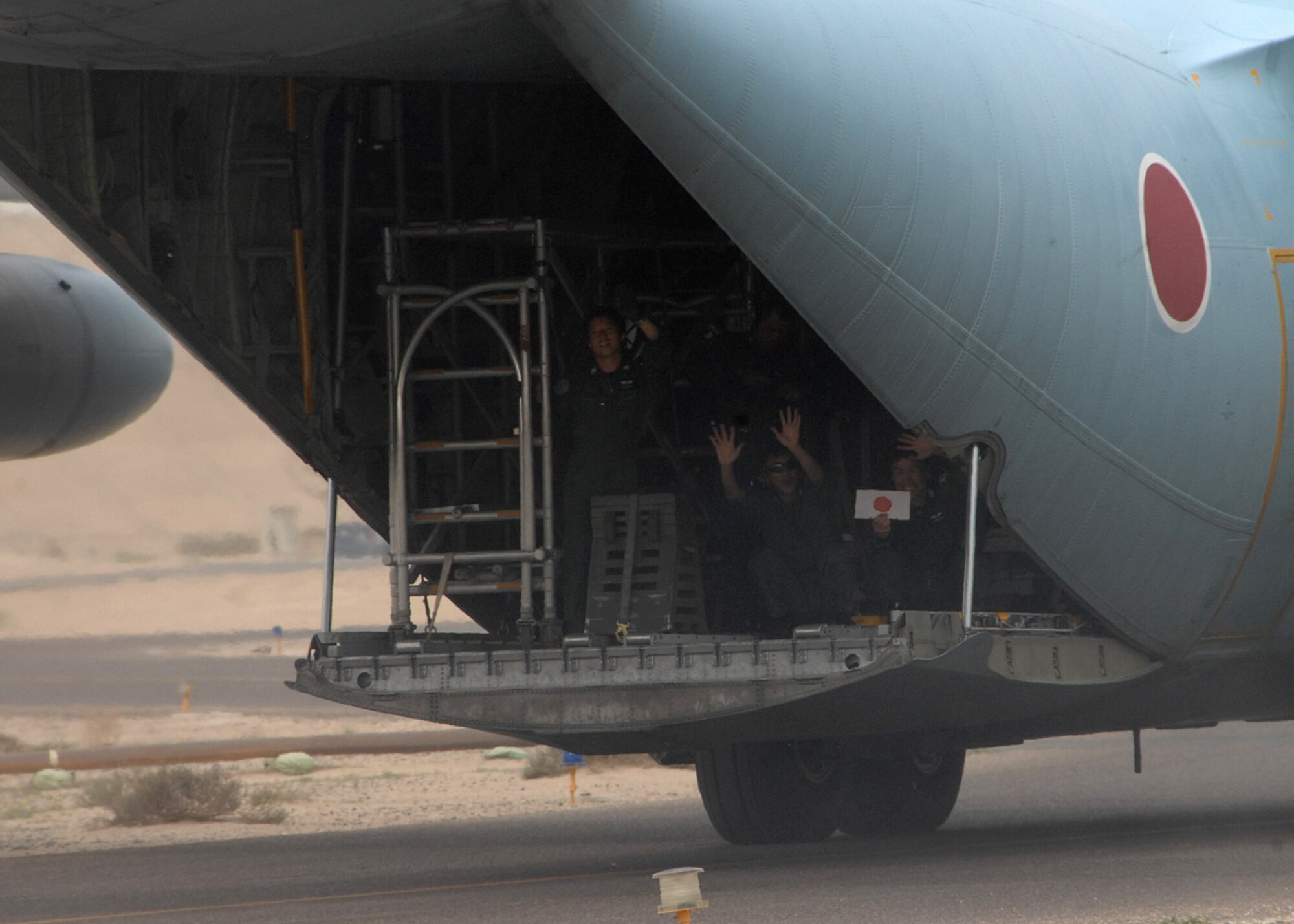 SOUTHWEST ASIA -- Members of the Japanese Air Self Defense Force Redeployment Group wave goodbye from the back of their C-130 at an air base in Southwest Asia, Feb. 10. The JASDF are returning to Japan after working alongside Coalition forces since 2004. (U.S. Air Force photo/Senior Airman Courtney Richardson)