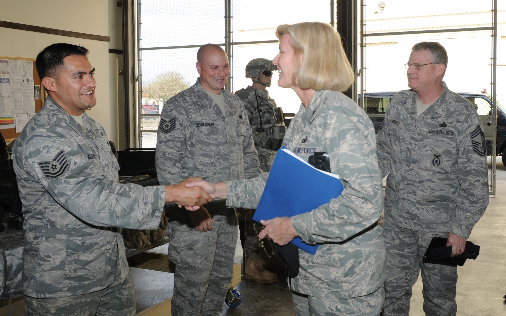 Brig. Gen. Mary Kay Hertog (second from right), Air Force security forces director, shakes hands with Tech. Sgt. Hugo Guerrero, 12th Security Forces Squadron, during a visit to Randolph Air Force Base Feb. 9. General Hertog and Chief Master Sgt. Bruce Broder (right), the security forces career-field manager, toured the squadron and discussed the general's vision with fellow security forces members before heading out to learn about the 12th SFS military working dog and combat arms flights. (U.S. Air Force photo by Rich McFadden)