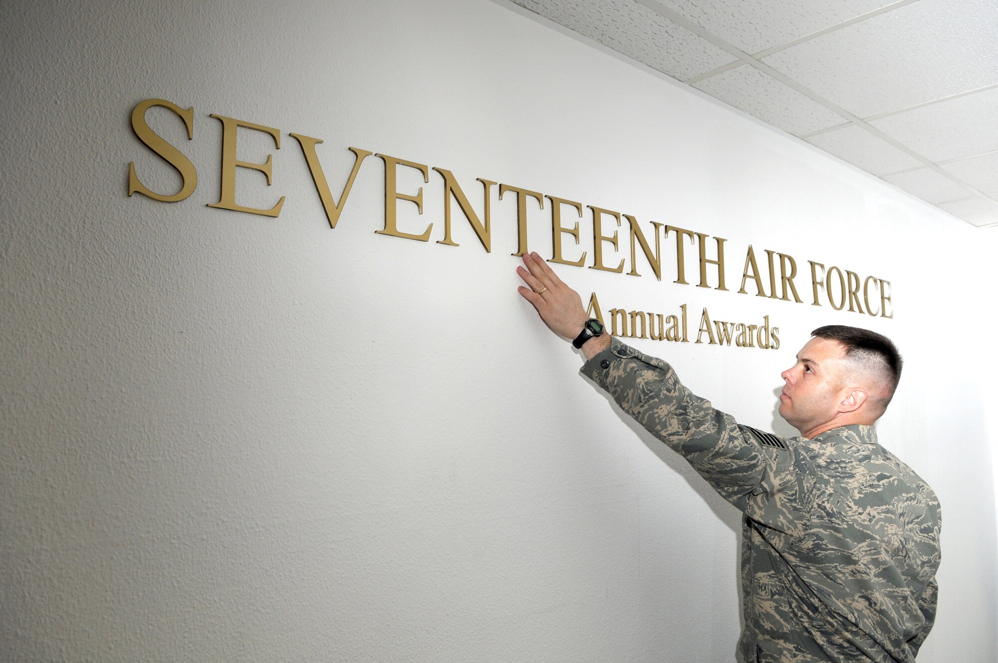 Seventeenth Air Force NCO of the Year Tech. Sgt. Lance Blocher puts the finishing touches on the new 17 AF annual and quarterly awards display Feb. 10 at the unit's headquarters. Sergeant Blocher and the other winners made significant contributions in building the unit, which reactivated Oct. 1, 2008. Standing up 17th AF from scratch has involved everything from planning to manning to refurbishing facilities, including new displays and signage for heraldry and recognition. 
Other winners include:  Airman of the Year – Senior Airman Vanessa Varoskovic; SNCO of the Year – Master Sgt. Rich Rizzo; Compnay Grade Officer of the Year – Maj. (then-Capt.) Jennifer Boudreau; Field Grade Officer of the Year – Maj. William Barron. Congratulations to all 17th AF outstanding Airmen for 2008! 
(Air Force Photo by Master Sgt. Jim Fisher) 