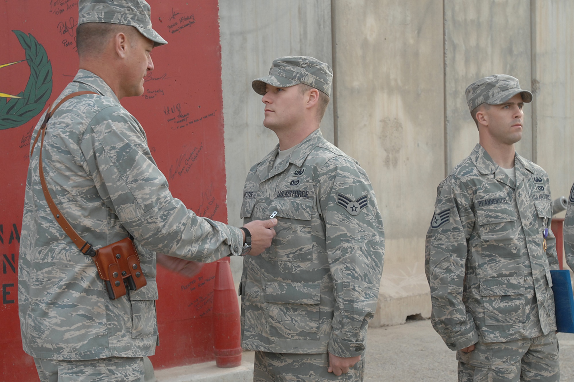 KIRKUK REGIONAL AIR BASE, Iraq – Senior Airman Robert Wester, 506th Expeditionary Civil Engineer Squadron explosive ordnance disposal technician, receives the Purple Heart medal from Brig. Gen. Brian Bishop, 332nd Air Expeditionary Wing commander, here Feb. 4. Airman Wester was awarded the decoration for wounds received in action following an improvised explosive device detonation Jan. 3. The Knoxville, Tenn., native is deployed to this air base in northern Iraq from Hickam AB, Hawaii. (U.S .Air Force photo / Senior Airman Eunique Stevens)