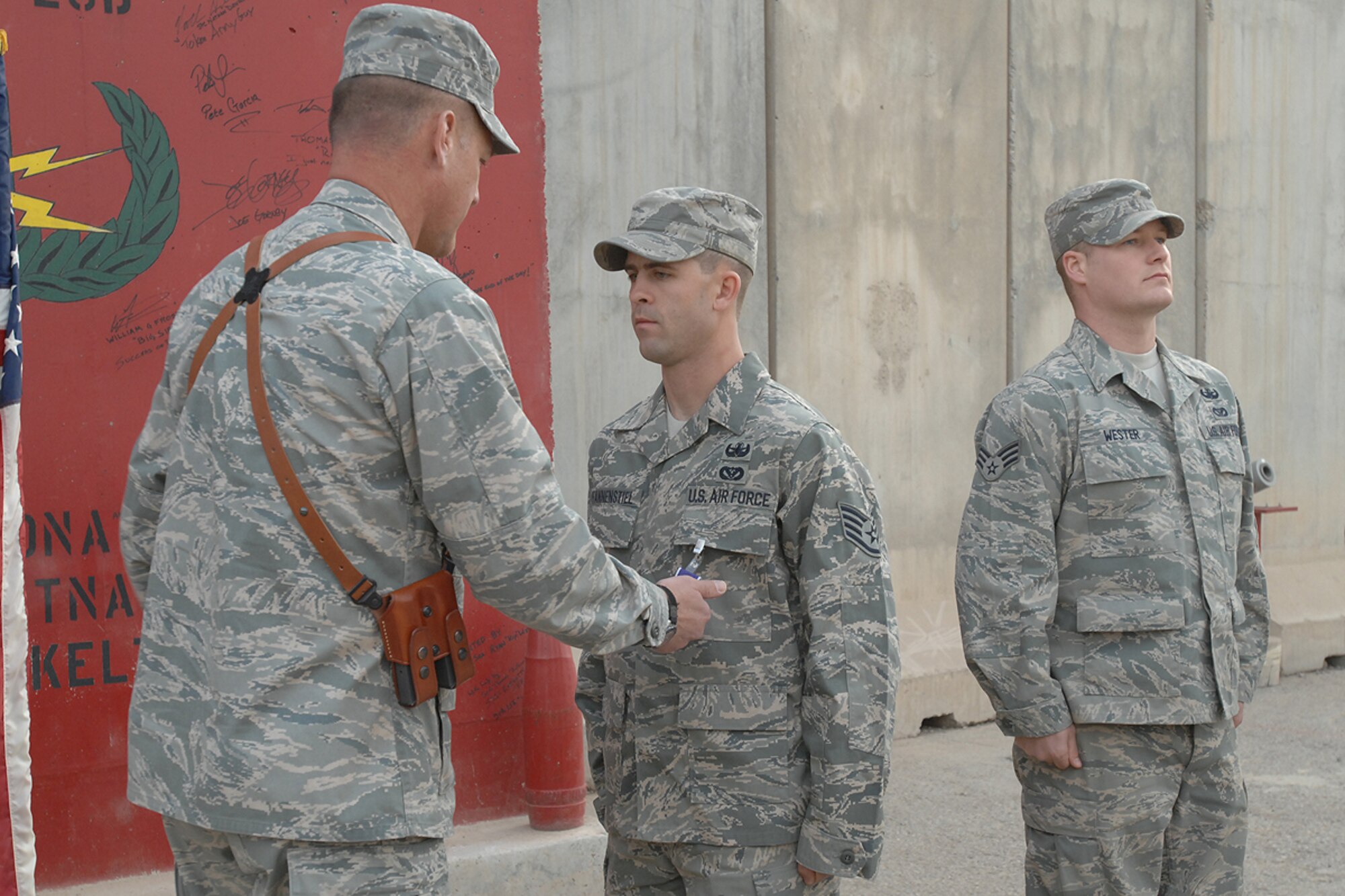 KIRKUK REGIONAL AIR BASE, Iraq – Staff Sgt. Brandon Pfannenstiel, 506th Expeditionary Civil Engineer Squadron explosive ordnance disposal technician, receives the Purple Heart medal from Brig. Gen. Brian Bishop, 332nd Air Expeditionary Wing commander, here Feb. 4. Sergeant Pfannenstiel was awarded the decoration for wounds received in action following an improvised explosive device detonation Jan. 3. The Midland, Texas, native is deployed to this air base in northern Iraq from Whiteman AFB, Mo. (U.S. Air Force photo / Senior Airman Eunique Stevens)