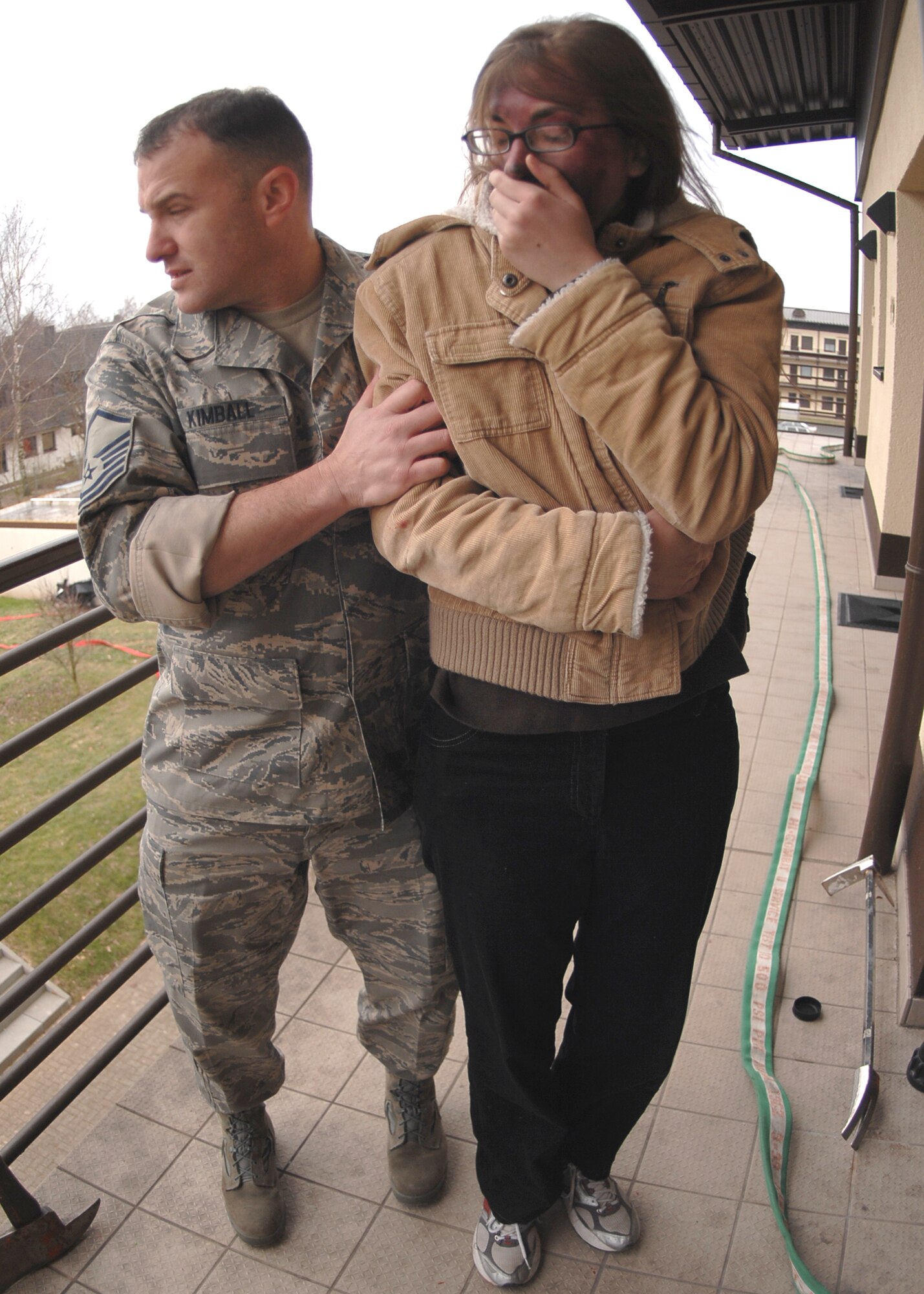SPANGDAHLEM AIR BASE, Germany -- Master Sgt. Gary Kimball, 52nd Fighter Wing, escorts Senior Airman Angela Royster, 52nd Contracting Squadron, to safety during an exercise Jan.  29, 2009.  The Emergency Management Major Accident War Trophy Munition exercise trains military personnel for real-life situations by testing the base’s response skills and capabilities. (U.S. Air Force photo by Airman 1st Class Nicholas Wilson)