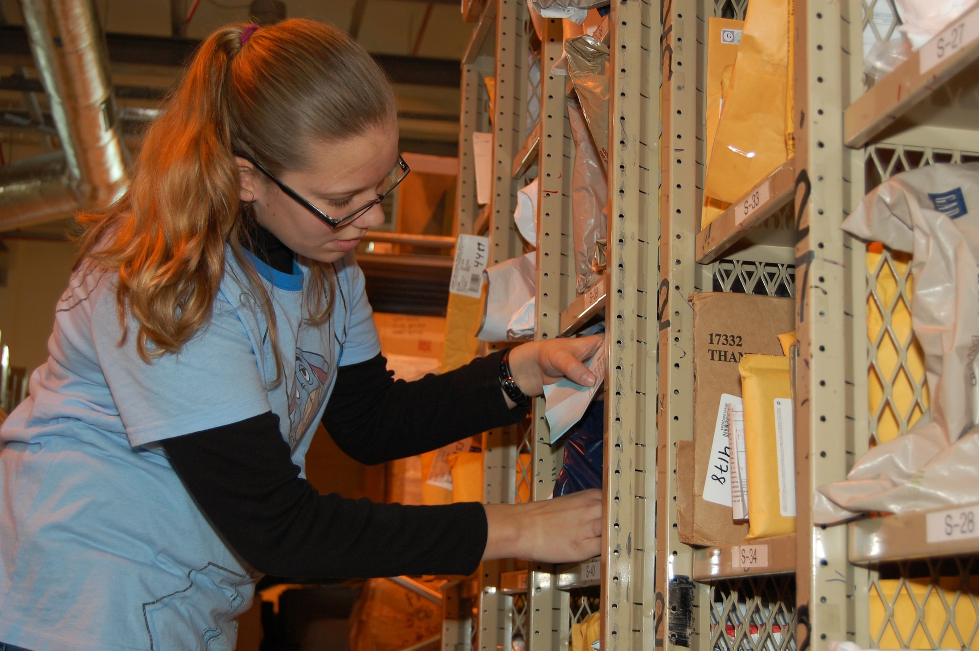 Aviano High School student Taylor Spaulding searches for a customer?s package at the base post office Feb. 5. Taylor shadowed post office workers throughout the day as part of the school?s annual Job Shadow Day. (U.S. Air Force photo/Staff Sgt. Lindsey Maurice)