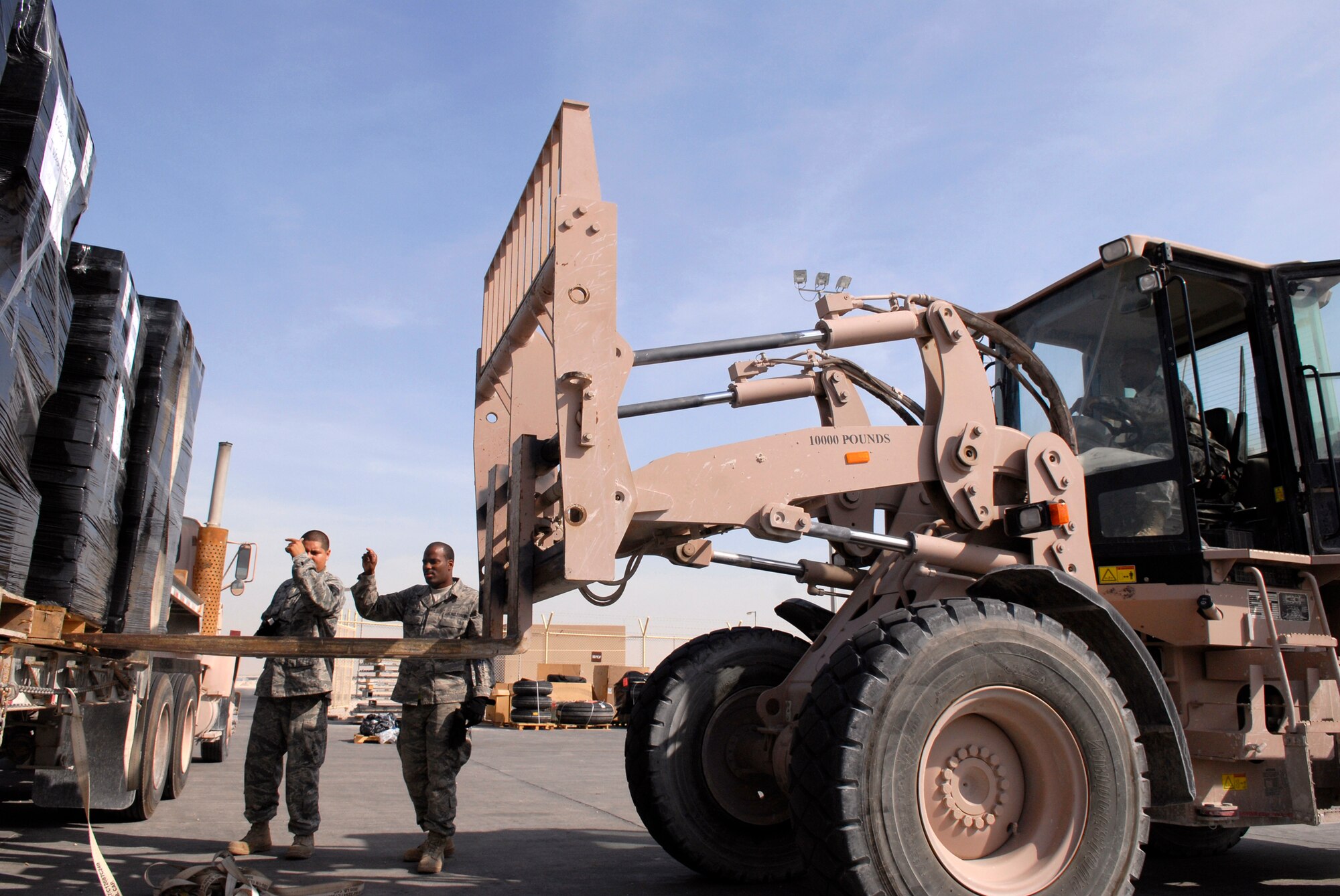 Senior Airman Frank Maguina and Senior Airman Michael Vanlear, 379th Expeditionary Logistics Readiness Squadron (ELRS) Traffic Management Apprentices, and Staff Sergeant Leviticus Robinson, 379th ELRS NCOIC Shipment and Planning, load AAFES cargo to be shipped out to other bases in the U.S. Central Command's area of responsibility, Feb. 10, 2009, at an undisclosed location in Southwest Asia.  Senior Airman Maguina hails from Long Island, N.Y. and is deployed from Langley Air Force Base (AFB), Va.  Senior Airman Vanlear hails from Oklahoma City, Okla. and is deployed from Charleston AFB, S.C.  Staff Sgt. Robinson hails from Mobile, Ala. and is deployed from Keesler AFB, Miss.  All three Airmen are deployed in support of Operation Iraqi and Enduring Freedom and Combined Joint Task Force- Horn of Africa.  (U.S. Air Force photo/Airman 1st Class Andrew Satran/released)    