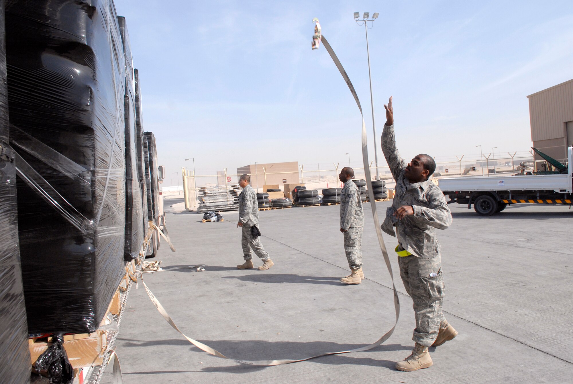 Senior Airman Michael Vanlear, a 379th ELRS Traffic Management Apprentice, throws a cargo strap to the other side of an AAFES shipment, for distribution to other bases in the U.S. Central Command's area of responsibility Feb. 10, 2009, at an undisclosed location in Southwest Asia.  Senior Airman Vanlear hails from Oklahoma City, Okla., and is deployed from Charleston AFB, S.C. in support of Operation Iraqi and Enduring Freedom and Combined Joint Task Force- Horn of Africa.  (U.S. Air Force photo/Airman 1st Class Andrew Satran/released)