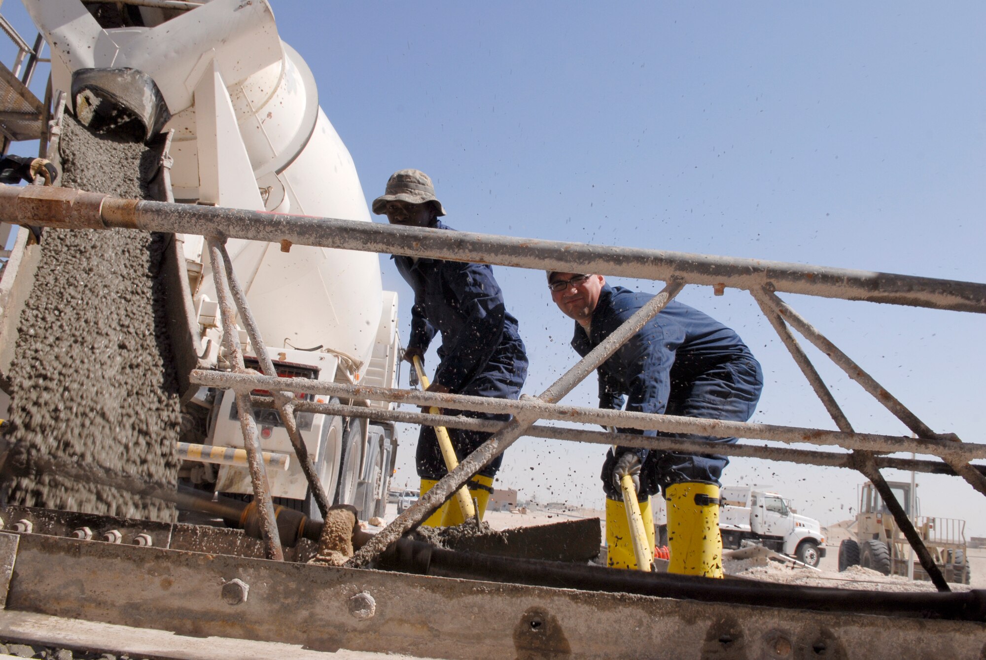 Airman 1st class Dominique Colvin and Staff Sergeant Sean Bilodeau smooth and even out the cement for a new loading dock at the base Individual Equipment and Supply store, Feb. 9, 2009, at an undisclosed location in Southwest Asia.  Airman 1st Class Colvin hails from Lumberton, N.C. and is deployed from Lackland AFB, Texas.  Staff Sgt. Bilodeau hails from Lincoln, R.I. and is deployed from Pope AFB, N.C.  Both are deployed in support of Operation Iraqi and Enduring Freedom and Combined Joint Task Force- Horn of Africa.  (U.S. Air Force Photo by Airman 1st Class Andrew Satran/Released)