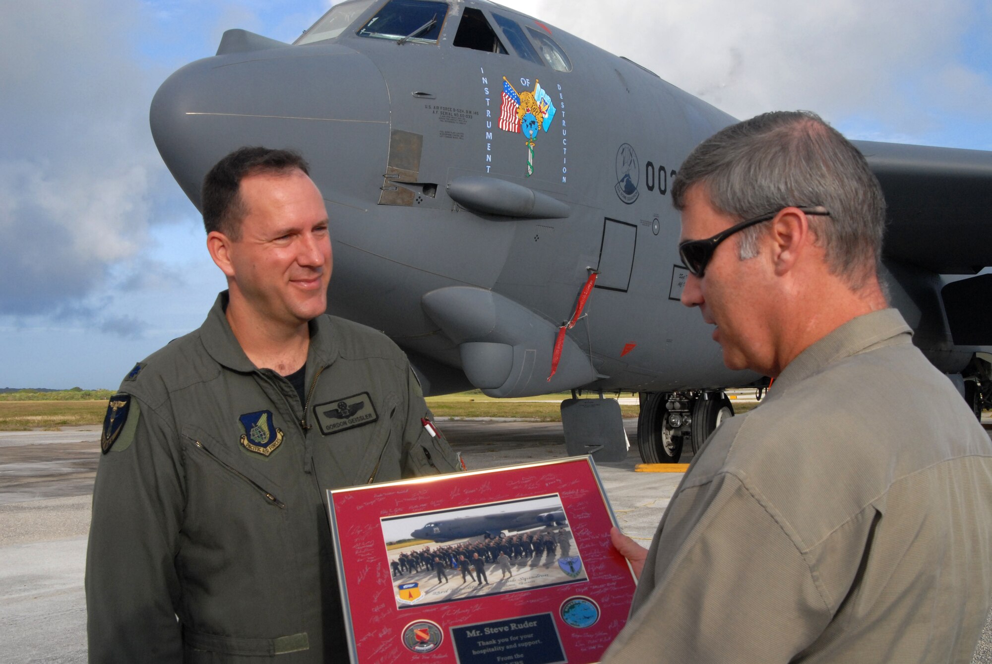 Lt. Col Gordon Geissler,  23rd Expeditionary Bomb Squadron commander,  presents Mr. Steve Ruder and other members of the Guam Chamber of Commerce with a portrait of members of the 23rd EBS during an orientation visit to Andersen Air Force Base, Guam, Feb. 10.  Members of the the 23rd EBS, deployed from Minot Air Force Base, N.D., in support of Andersens Global Deterrence mission,  briefed members of the Chamber of Commerce on the capabilities that the 23rd EBS brings to the Pacific region. (U.S. Air Force photo by Senior Airman Ryan Whitney)