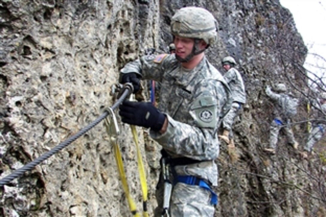 U.S. Army Spc. Stephen Buck, assigned to the 2nd Stryker Calvary Regiment, slides along a "klettersteig" as part of an Installation Management Command-Europe Warrior Adventure Quest outing in Hirschbachtal, Germany, Jan. 23, 2009.