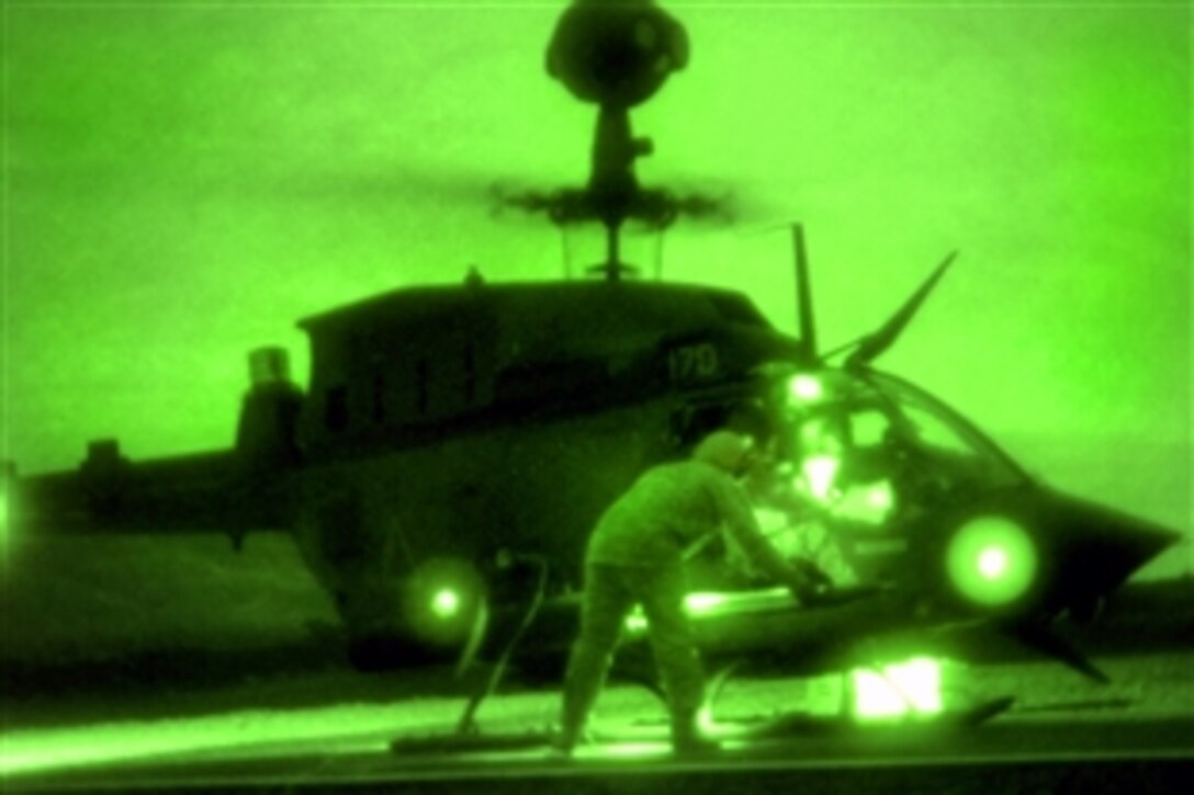 Seen through a night-vision device, a U.S. Army soldier re-arms an OH-58 Kiowa Warrior helicopter with a rocket during night aerial gunnery at the Pohakuloa Training Area, Hawaii, Feb. 5, 2009. The crews and helicopters are assigned to the 2nd Squadron, 6th Cavalry Regiment, 25th Combat Aviation Brigade.