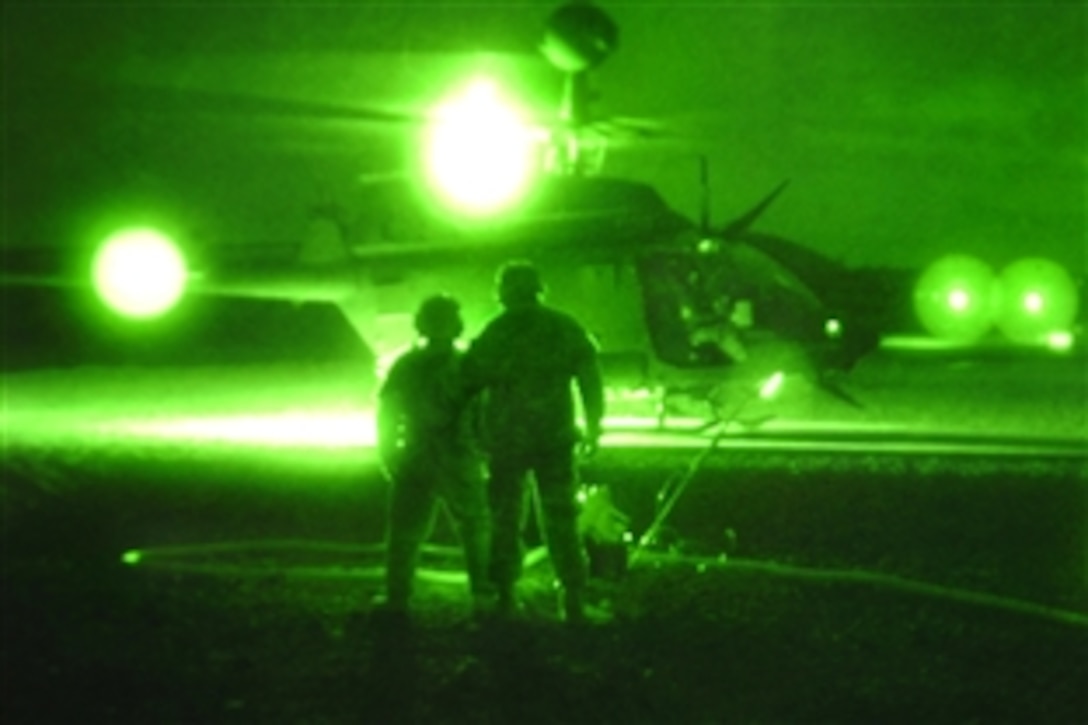 As seen through a night-viewing device, U.S. Army soldiers step away from an OH-58 Kiowa Warrior helicopter after fueling it during aerial gunnery operations at the Pohakuloa Training Area, Hawaii, Feb. 5, 2009. The crews and helicopters are assigned to the 2nd Squadron, 6th Cavalry Regiment, 25th Combat Aviation Brigade.