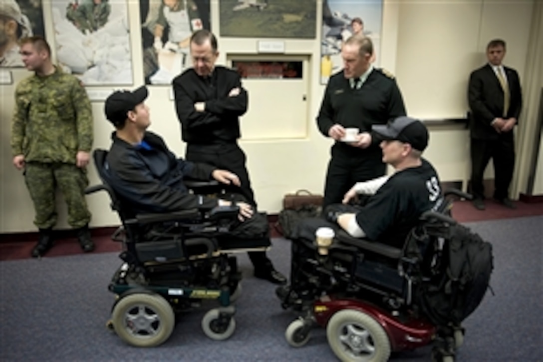 U.S. Navy Adm. Mike Mullen, chairman of the Joint Chiefs of Staff, and Army Gen. Walt Natynczyk, Canadian chief of Defense, speak with Canadian servicemembers Master Cpl. Mike Trauner, left, and Cpl. Bill Kerr during a visit with Canadian Enduring Freedom veterans in Ottawa, Canada, Feb. 10, 2009.
