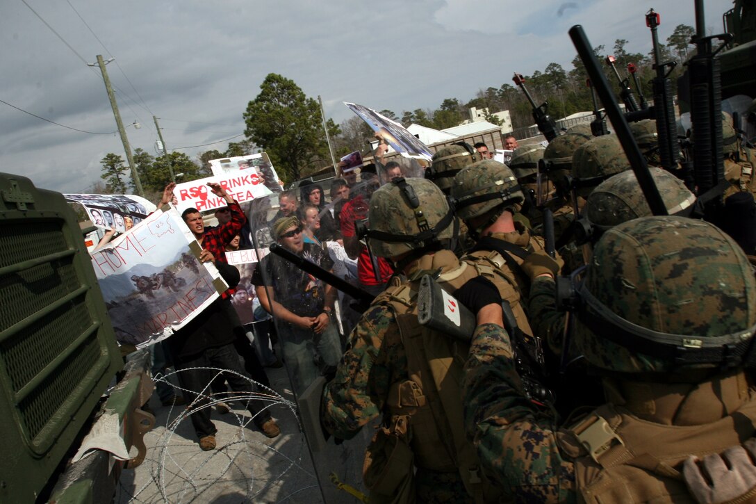 Marines from Sierra Battery, Battalion Landing Team, 3rd Battalion, 2nd Marine Regiment, 22nd Marine Expeditionary Unit, face off against Marines roleplaying protesters outside the gates of a mock American embassy compound during an embassy reinforcement exercise aboard Camp Lejeune, N.C. Feb. 10, 2009. The reinforcement exercise was part of Composite Training Unit Exercise, a  part of the 22nd MEU's pre-deployment training program. The 22nd MEU is scheduled to deploy this spring. (Official Marine Corps photo by Staff Sgt. Matt Epright)