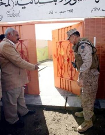 Ashoor Primary School headmaster, Ahmad Freh Metlaq Khalaf, invites 2nd Marine Logistics Group commanding general, Brig. Gen. Juan G. Ayala, to tour the newly renovated school after a ribbon-cutting ceremony in Al Kabani, Iraq, Feb. 11. The renovations created more space for students and made it possible to accommodate an extra grade level at the school.