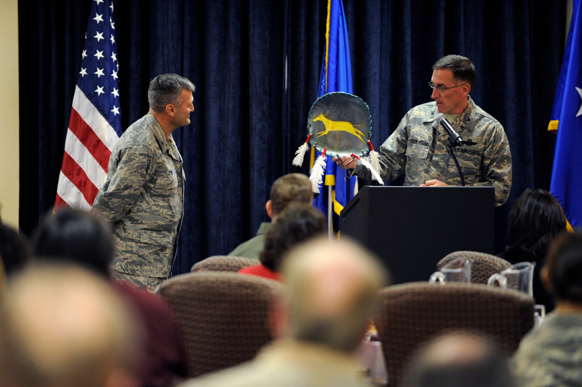 (Right) Col. Scott Vander Hamm, 28th Bomb Wing commander, presents Chaplain (Brig. Gen.) David Cyr, Air Force Deputy Chief of Chaplains, with a shield during the National Prayer Luncheon here, Feb. 10.  According to the Native Americans of the Northern Great Plains, a shield was one of the most important spiritual objects, and represented all a person believed in. (U.S. Air Force photo/Airman 1st Class Matthew Flynn)