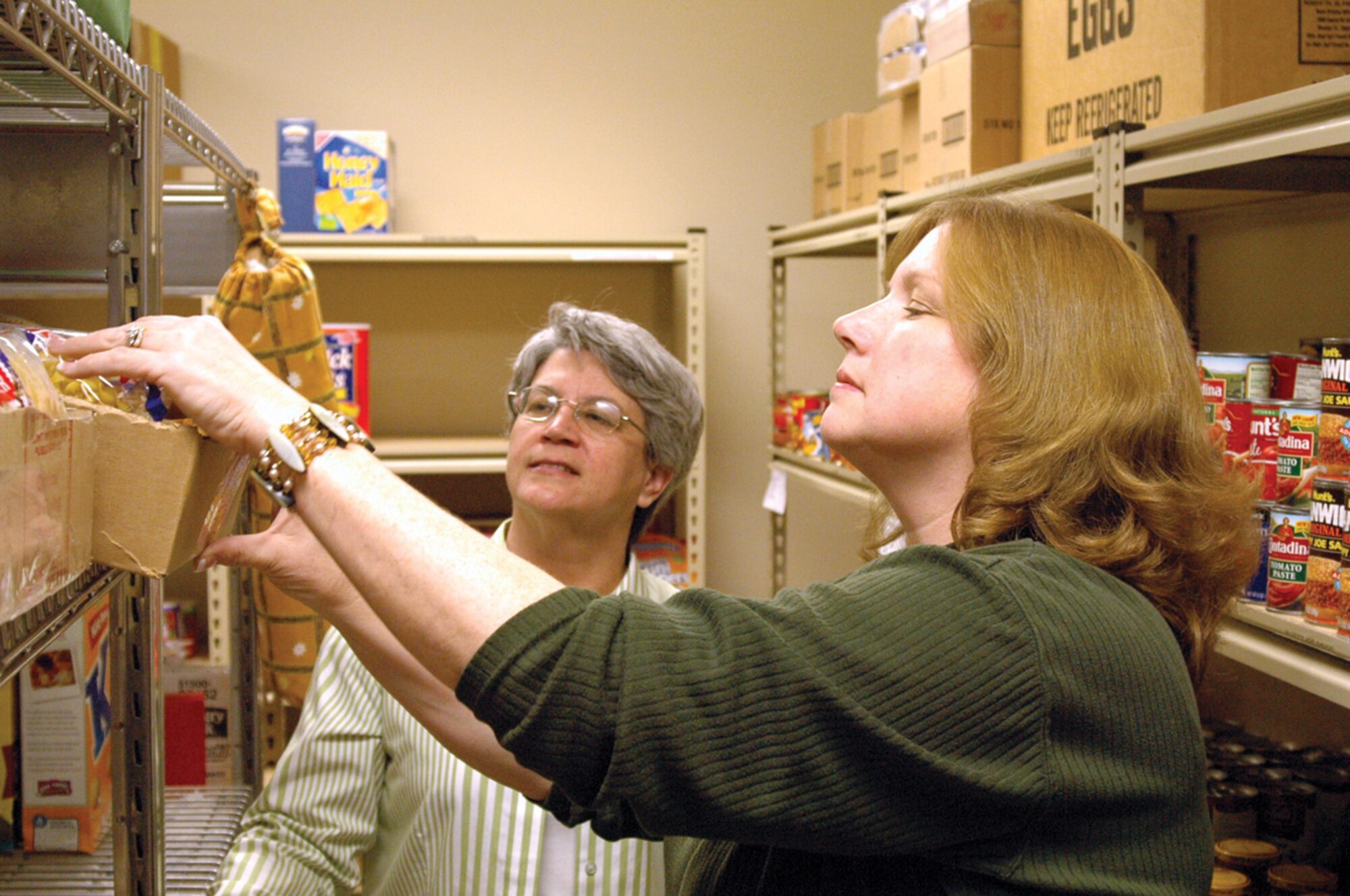 Kim Marks, new Tinker Food Pantry coordinator, right, and Kathy Baker, food pantry volunteer, check stock levels in the pantry in preparation for a food drive this weekend. Ms. Marks recently took over the coordinator duties, which include overseeing the pantry’s food stocks, volunteer work schedules and special events such as Saturday’s food drive at the Tinker Commissary. Food pantry volunteers will be accepting donations at the commissary from 10 a.m. to 2 p.m. The Tinker Food Pantry is a Tinker Airman and Family Readiness Center program that provides food items for needy military families. For additional information about the food pantry call 739-2747. (Air Force photo/Ralph Monson) 