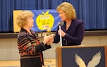 Debra Knapp, KENS 5 news anchor, presents the KENS 5/San Antonio Credit Union "Golden Apple ExCel Award" for teaching excellence to Donna Colglazier, an English teacher at Randolph High School on Feb. 10. (U.S. Air Force photo by Rich McFadden)