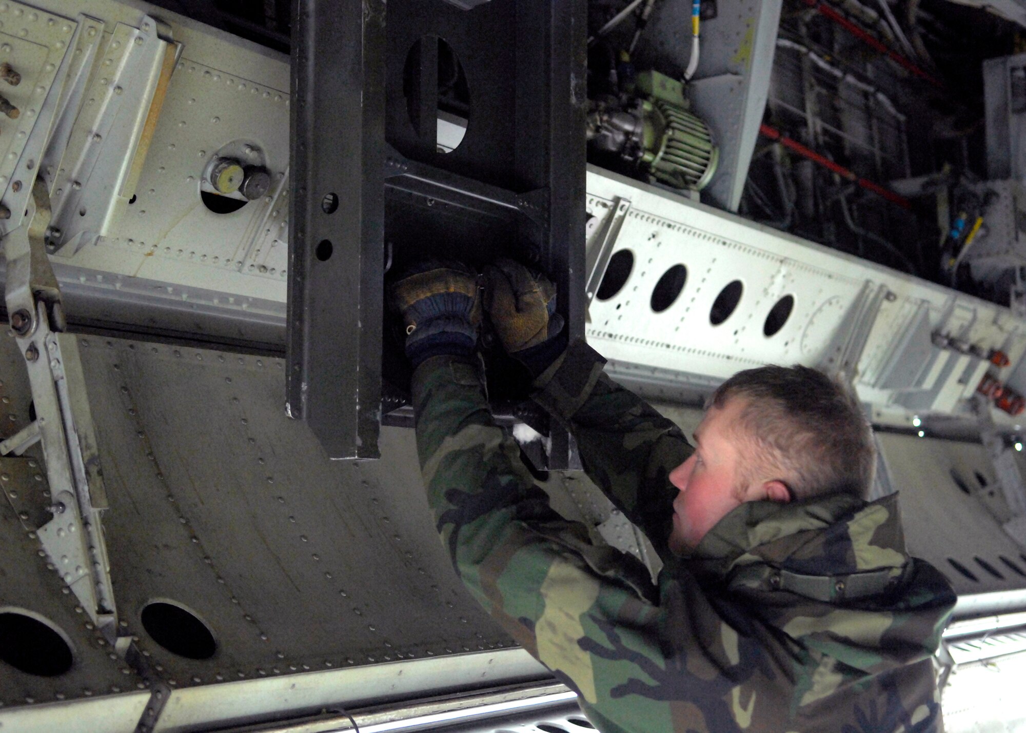 MINOT AIR FORCE BASE, N.D. -- Airman 1st Class Brady Fender, 5th Aircraft Maintenance Squadron weapons armament specialist, inspects the bomb rack inside a B-52H Stratofortress here Feb. 11.  Airman Fender, a native of Billings, Mont., has been assigned to the 5th AMXS for a year and a half. (U.S. photo by Staff Sgt. Keith Ballard)